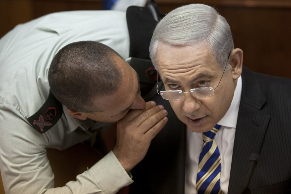 Israeli Prime Minister Benjamin Netanyahu, right, listens to Military Secretary Eyal Zamir.