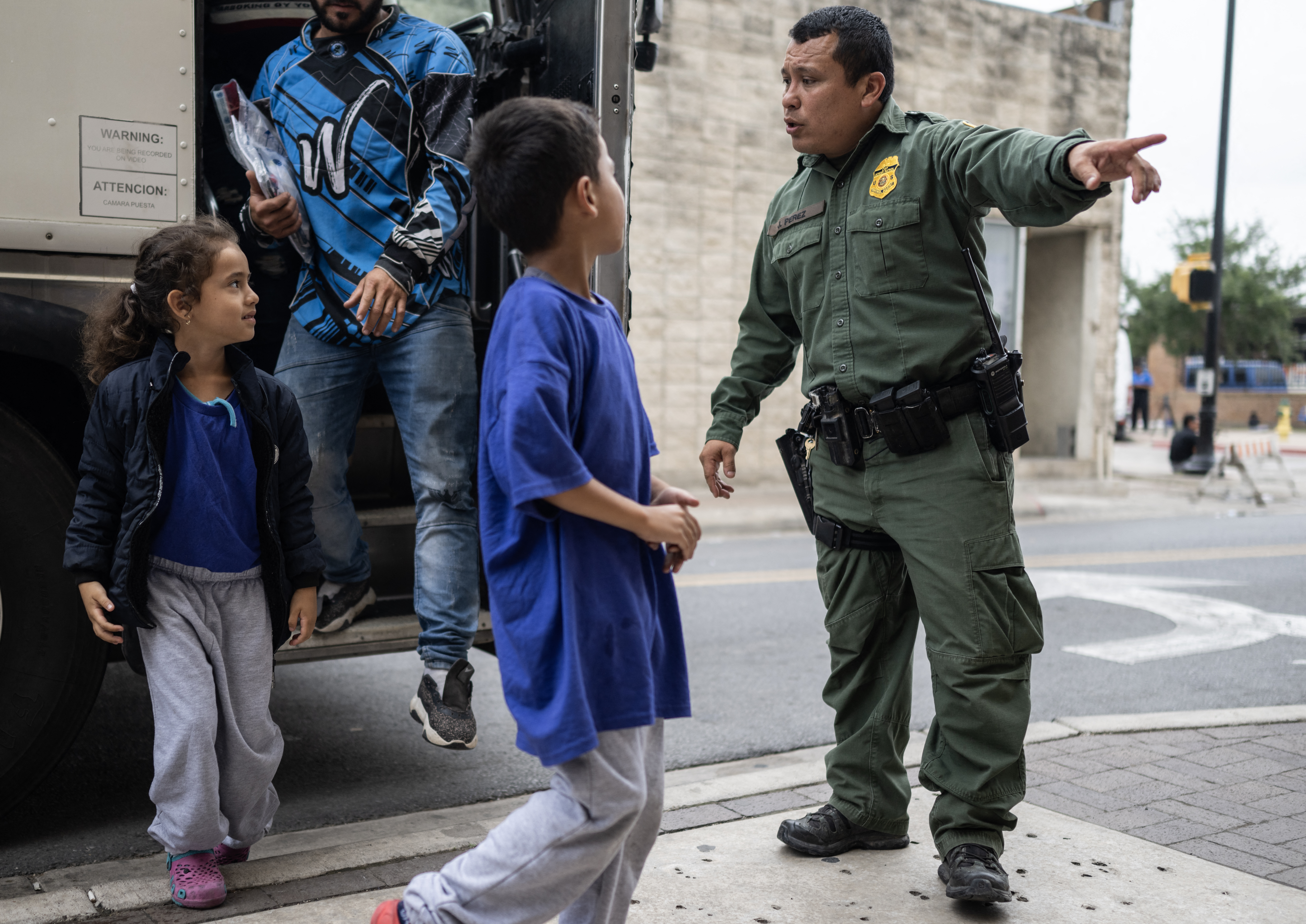 A Border Patrol agent looks on as recent migrant children and families get down from a bus at a processing center on May 11, 2023 in Brownsville, Texas. The US on May 11, 2023, will officially end its 40-month Covid-19 emergency, also discarding the Title 42 law, a tool that has been used to prevent millions of migrants from entering the country. (Photo by ANDREW CABALLERO-REYNOLDS / AFP)