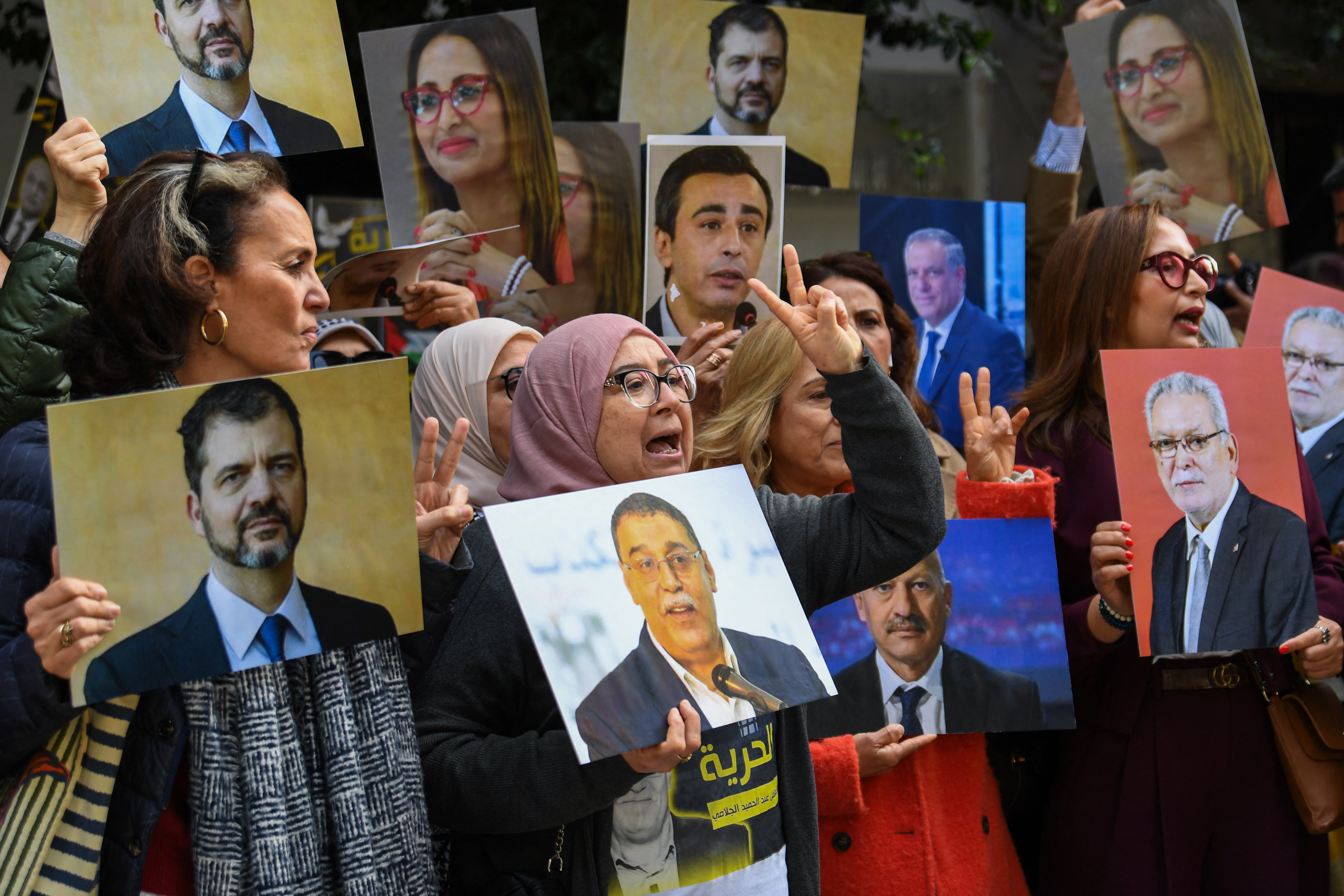 Relatives of detainees accused of involvement in a conspiracy case against state security, gesture on the day of a first hearing in front of the court in Tunis on March 4, 2025. The trial of around 40 high-profile Tunisian opposition figures is set to begin on March 4, with rights groups denouncing the case as politically motivated. The defendants include former diplomats, politicians, lawyers and media figures, some of whom have been outspoken critics of President Kais Saied. (Photo by FETHI BELAID / AFP)