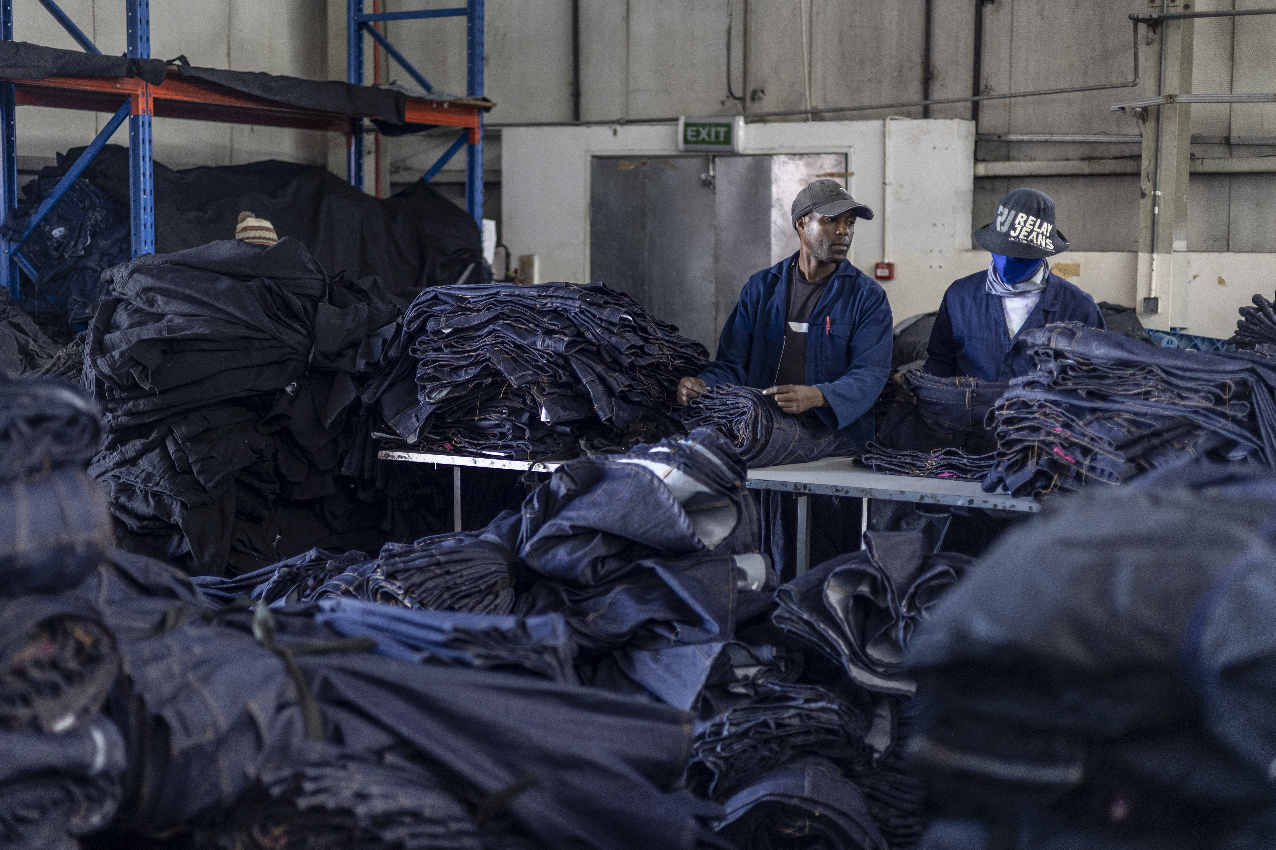 Workers pack completed jeans at the Afri-Expo Textile Factory in Maseru, Lesotho on March 19, 2025. In a sweltering factory in Lesotho, rows of workers hunch over thrumming sewing machines churning out piles of denim jeans for global shoppers from this country US President Donald Trump mocked as unknown. 