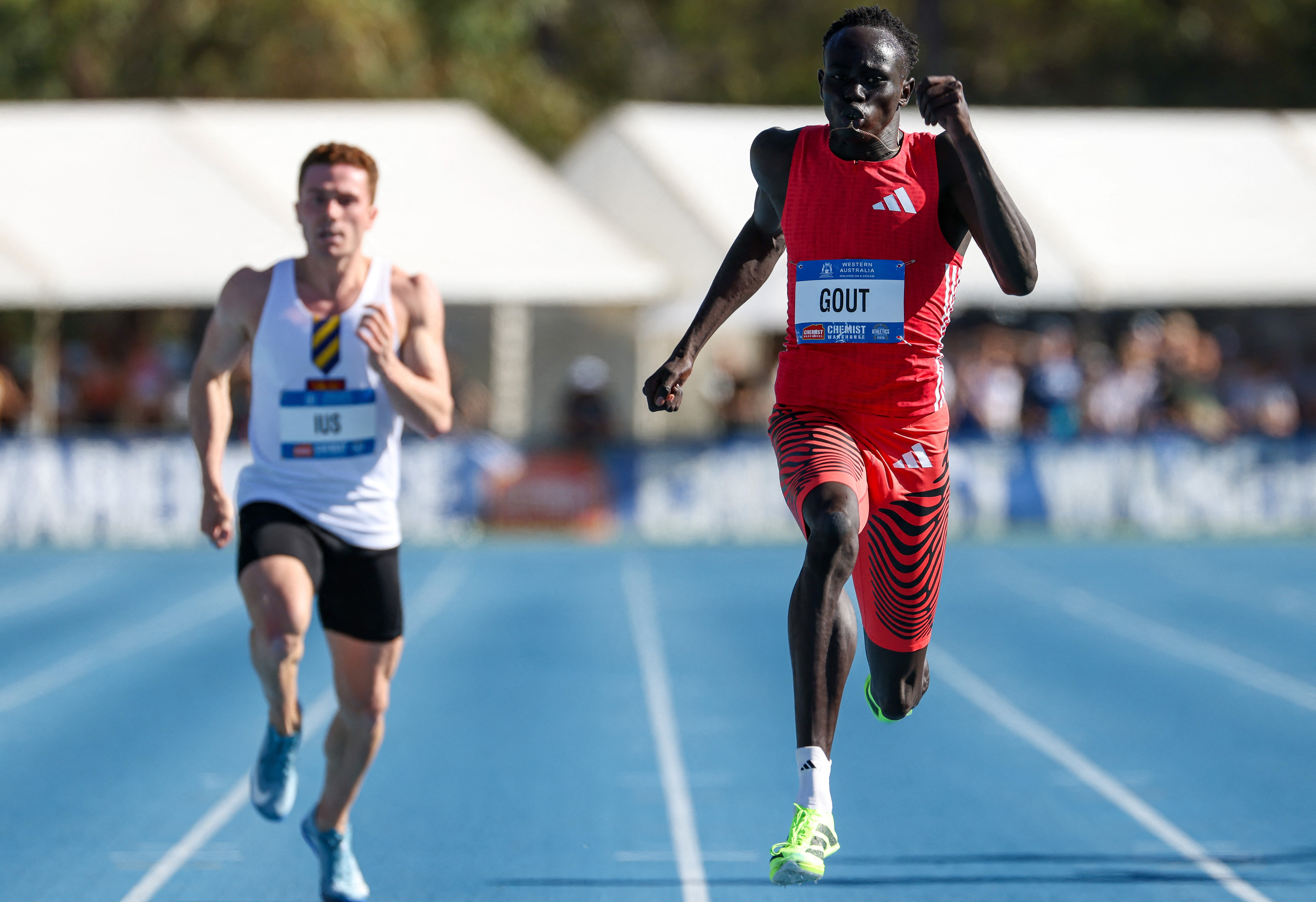 Australia's Gout Gout (R) crosses the finish line to win the men's 200m final during the Australian Athletics Championships in Perth on April 13, 2025. (Photo by COLIN MURTY / AFP) / -- IMAGE RESTRICTED TO EDITORIAL USE - STRICTLY NO COMMERCIAL USE --