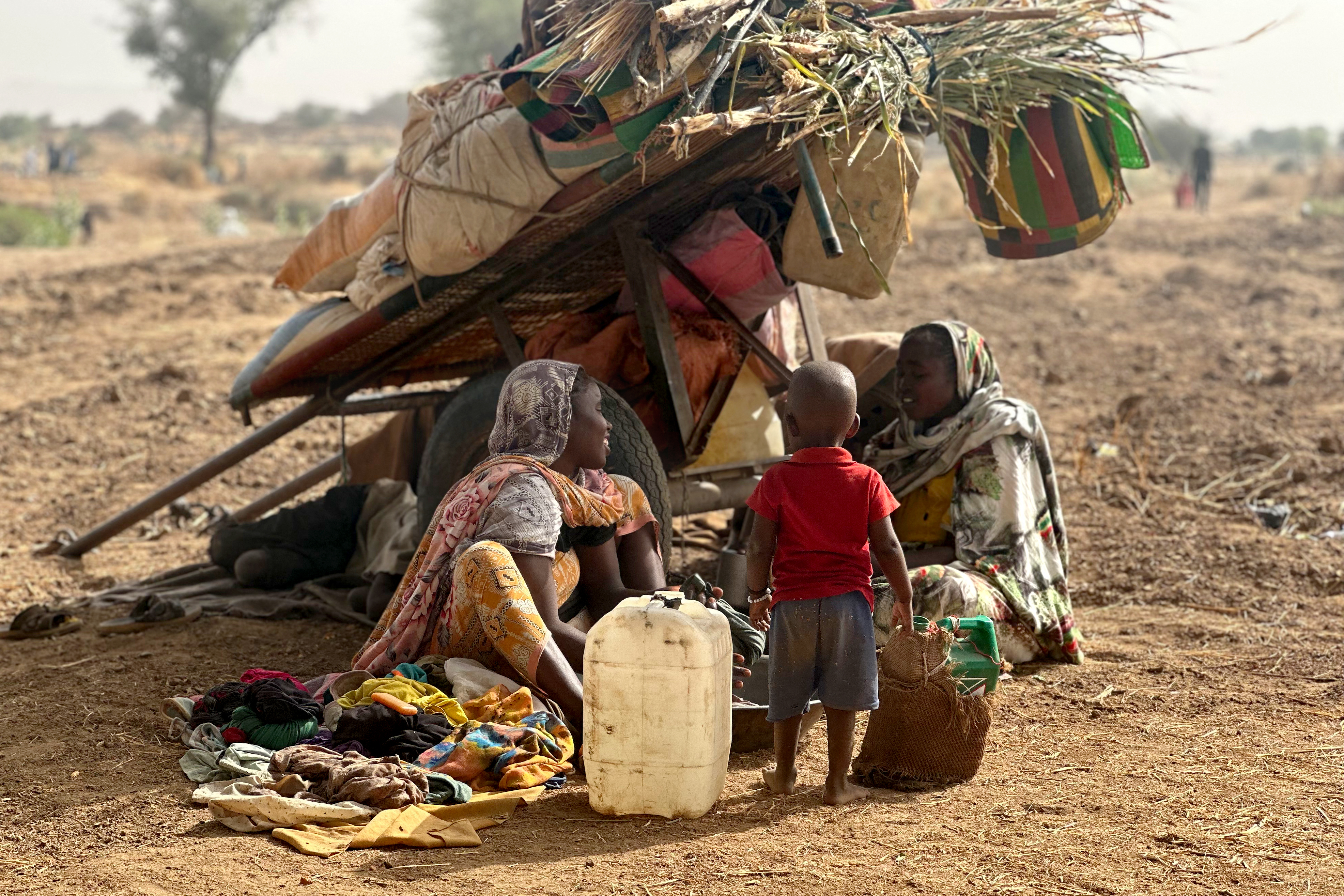 Displaced Sudanese women and children gather at a camp near the town of Tawila in North Darfur