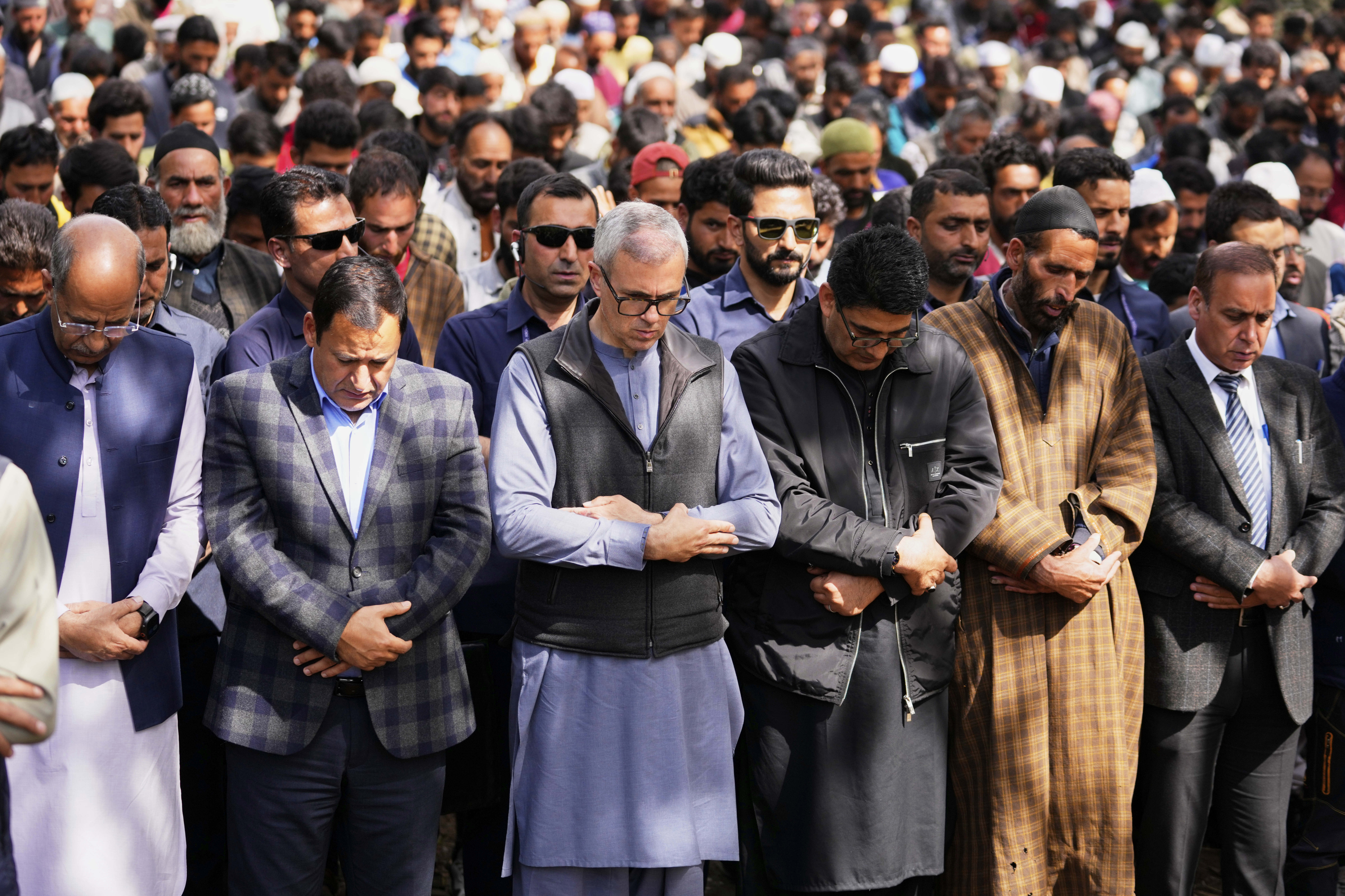 Chief Minister of Jammu & Kashmir, Omar Abdullah, front center, in a blue-gray shirt, prays with the congregation at the funeral of Adil Hussain Shah, a daily-wage worker, who died when militants indiscriminately opened fire on a crowd of mainly tourists on Tuesday, at his village Hapatnar, about 20 km (13 miles) from Pahalgam where the incident took place, Indian controlled Kashmir, Wednesday, April 23, 2025. (AP Photo/Dar Yasin)
