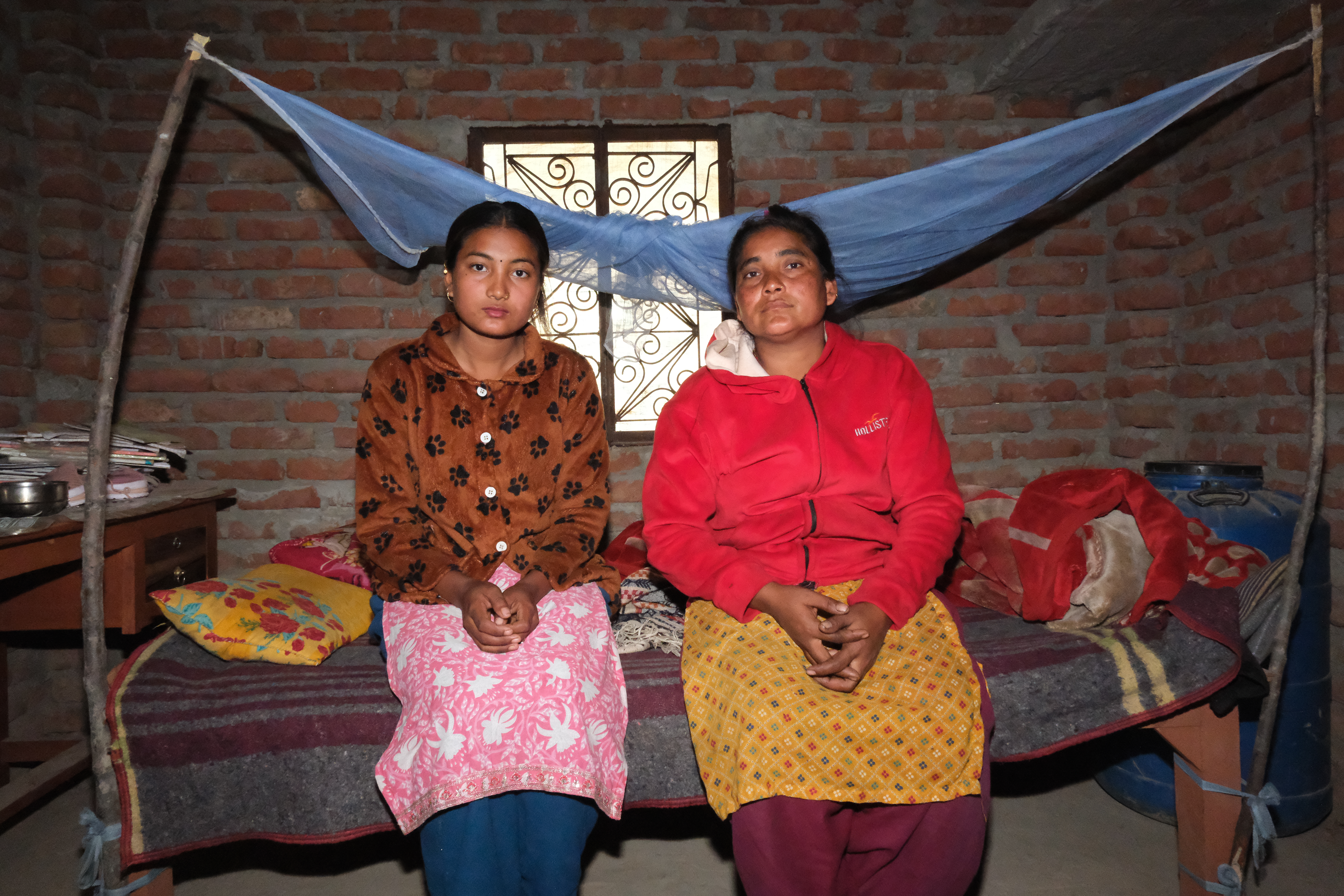 Khima, 18, and her mother, 36, sit in their home in Bardiya, Nepal [Mirja Vogel/Al Jazeera]