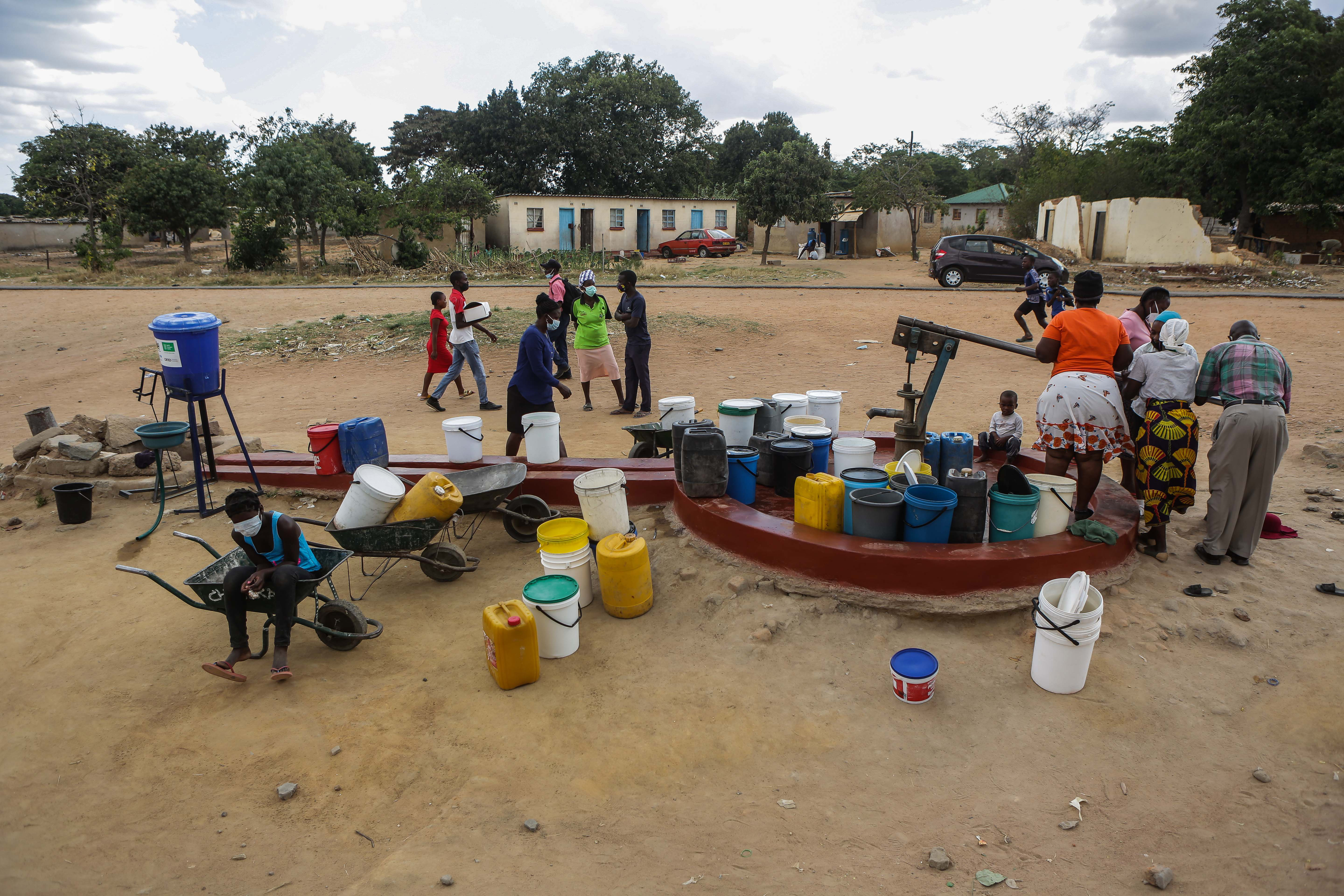 HARARE, ZIMBABWE - OCTOBER 28: Residents in Natsiraishe's community fetch water at a water point controlled by community members. The neighbourhood faces acute water shortages amongst early child marriages on October 28, 2021 in Epworth, Harare, Zimbabwe. Natsiraishe Maritsa uses Taekwondo sessions to teach and empower young girls in her community to prevent early child marriages. She is teaching about 130 people of school going age. According to UNICEF an additional 10 million girls are now at risk of becoming child brides by the end of the decade because of the COVID-19 pandemic. (Photo by Tafadzwa Ufumeli/Getty Images)