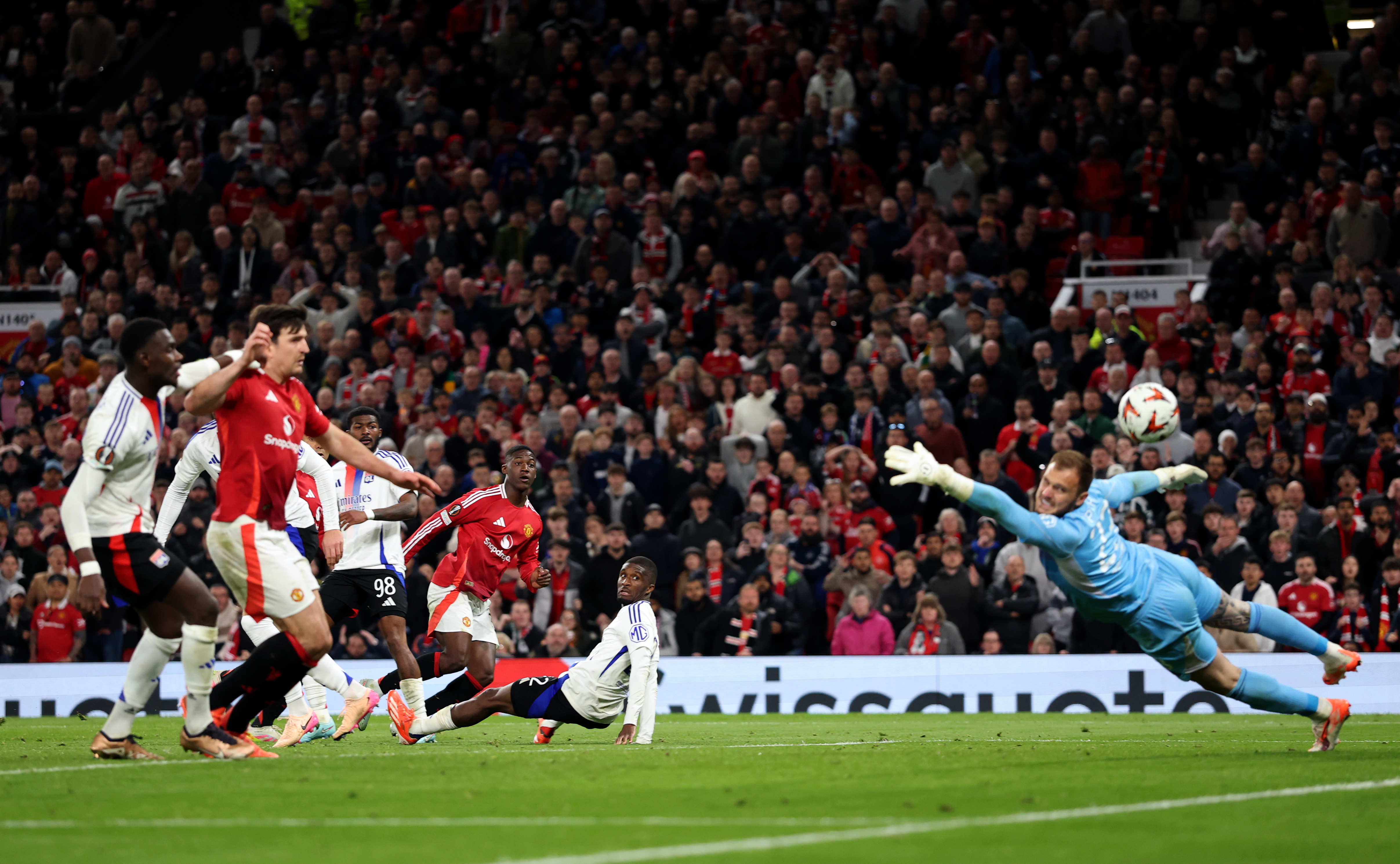 MANCHESTER, ENGLAND - APRIL 17: Kobbie Mainoo of Manchester United scores his team's fourth goal past Lucas Perri of Olympique Lyonnais during the UEFA Europa League 2024/25 Quarter Final Second Leg match between Manchester United and Olympique Lyonnais at Old Trafford on April 17, 2025 in Manchester, England. (Photo by Carl Recine/Getty Images)