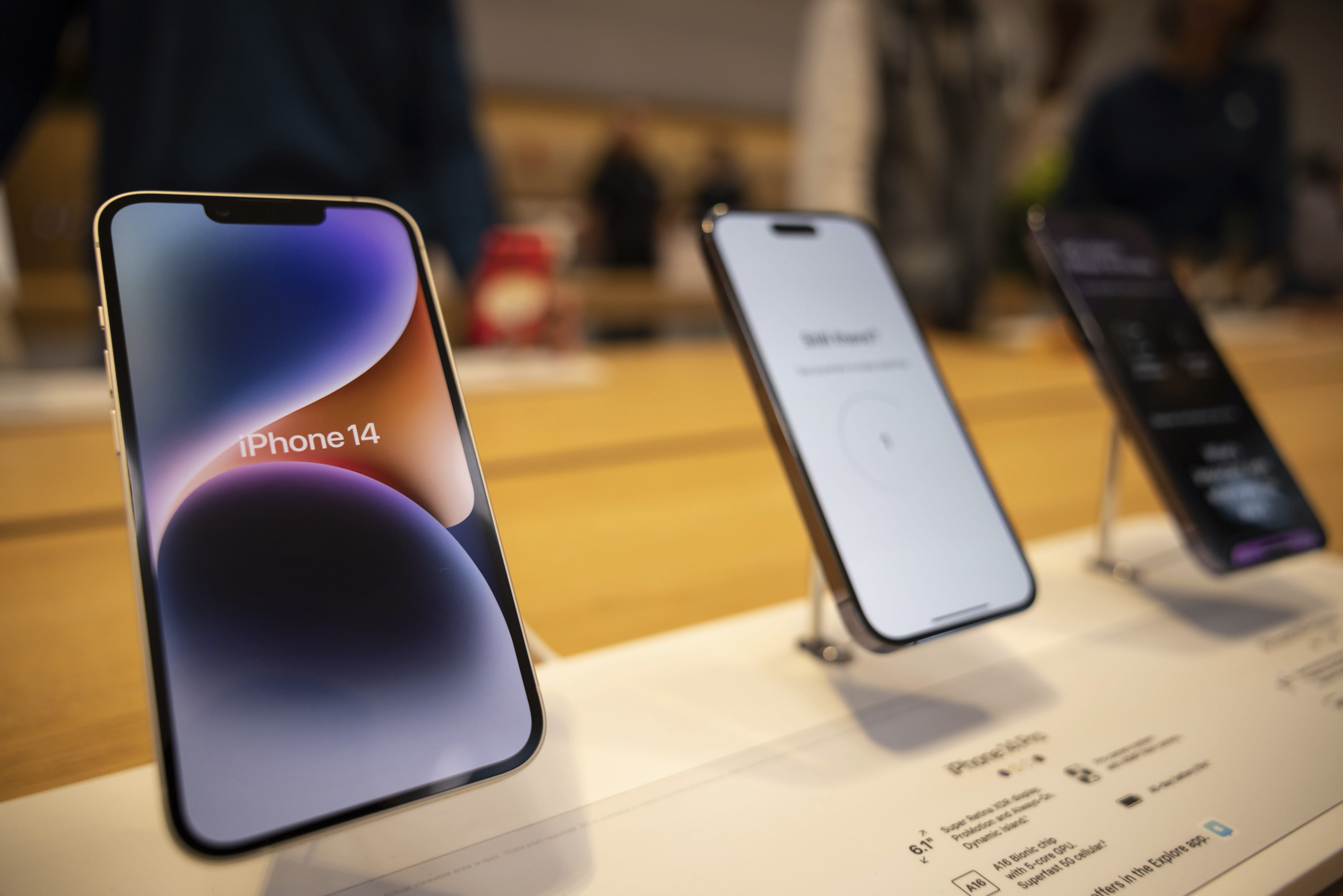 The iPhone 14, iPhone 14 Pro and iPhone 14 Pro Max are displayed in a store.