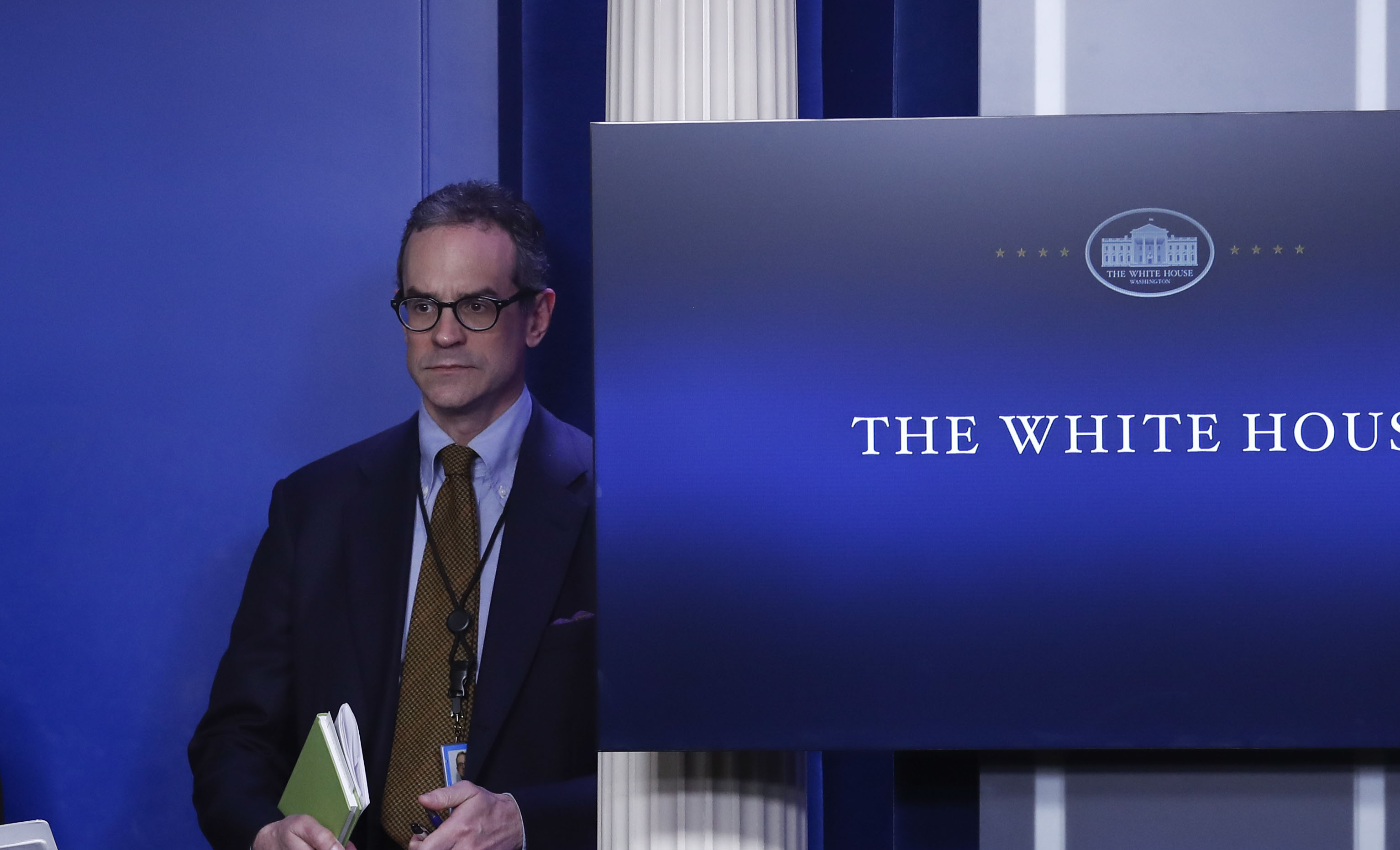 Michael anton near a screen that reads "The White House"