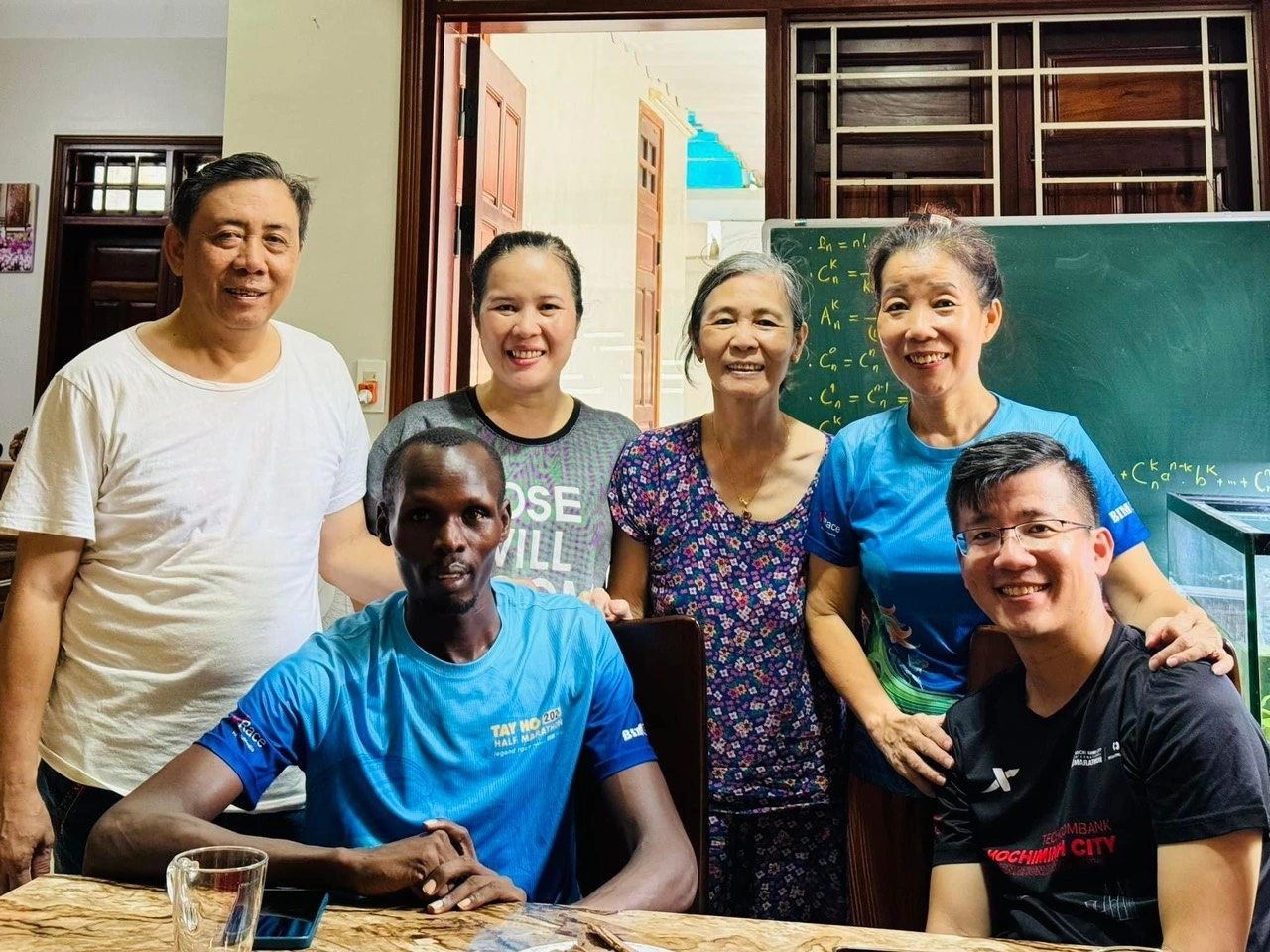 Edwin Kiptoo, front left, and Le Hoan, front right, with Le family relatives in Hanoi, Vietnam, in April 2024 [Danh Nguyen/Al Jazeera