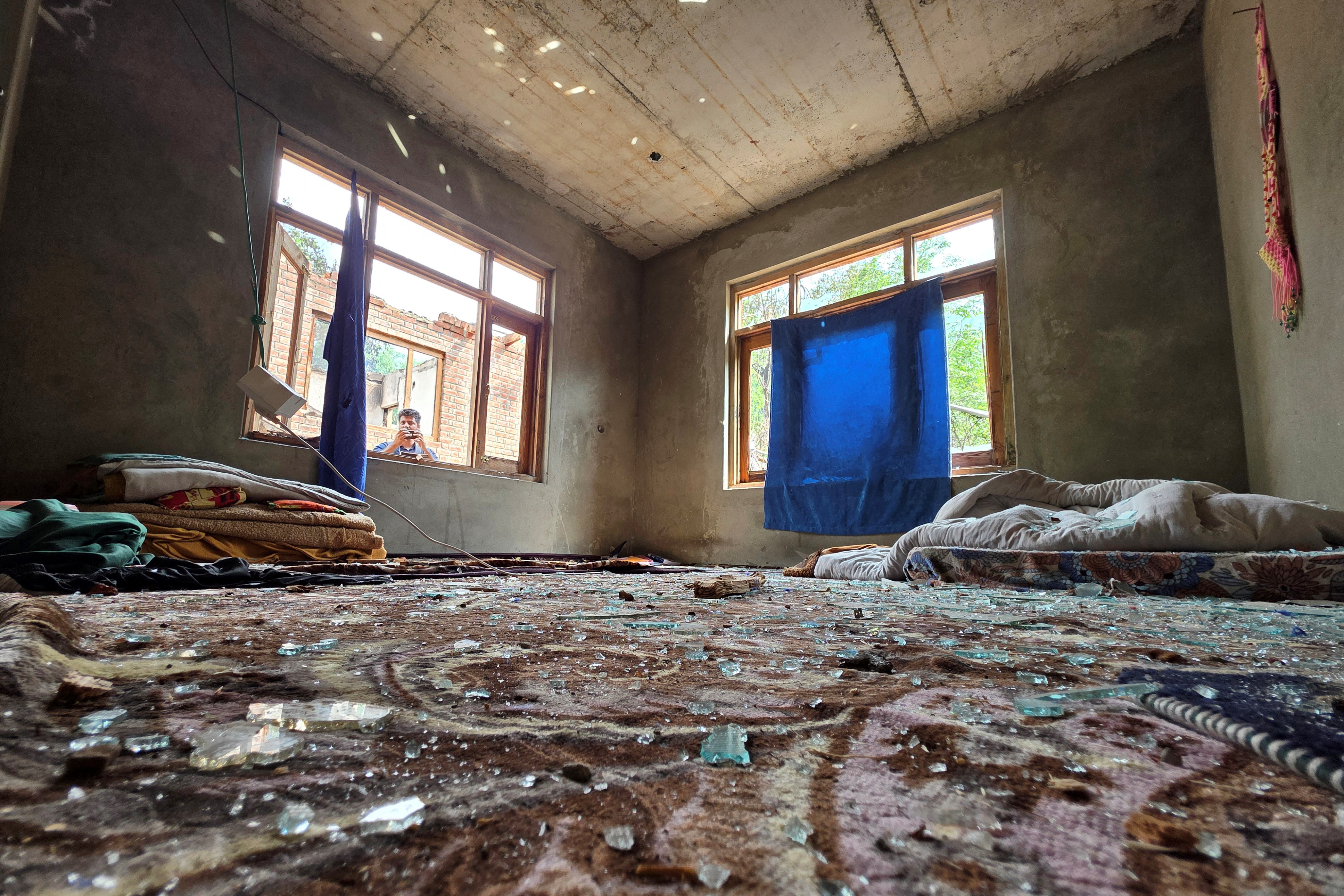 Broken glass pieces are seen on a carpet inside a residential house after it was partailly damaged by a cross-border shelling in Salamabad in India-administered Kashmir's Baramulla district, May 7, 2025. REUTERS/Stringer