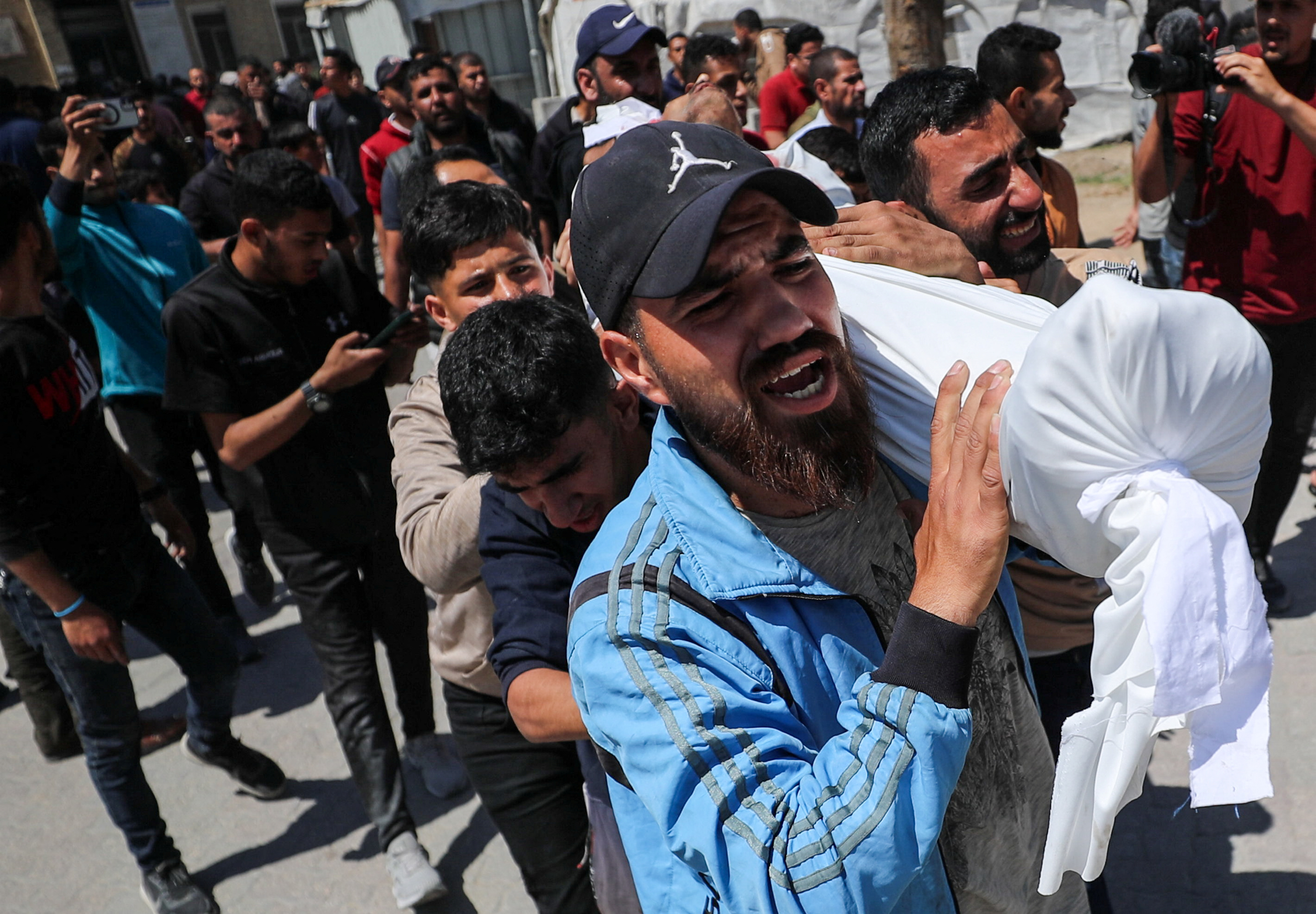 Mourners carry the body of a Palestinian.