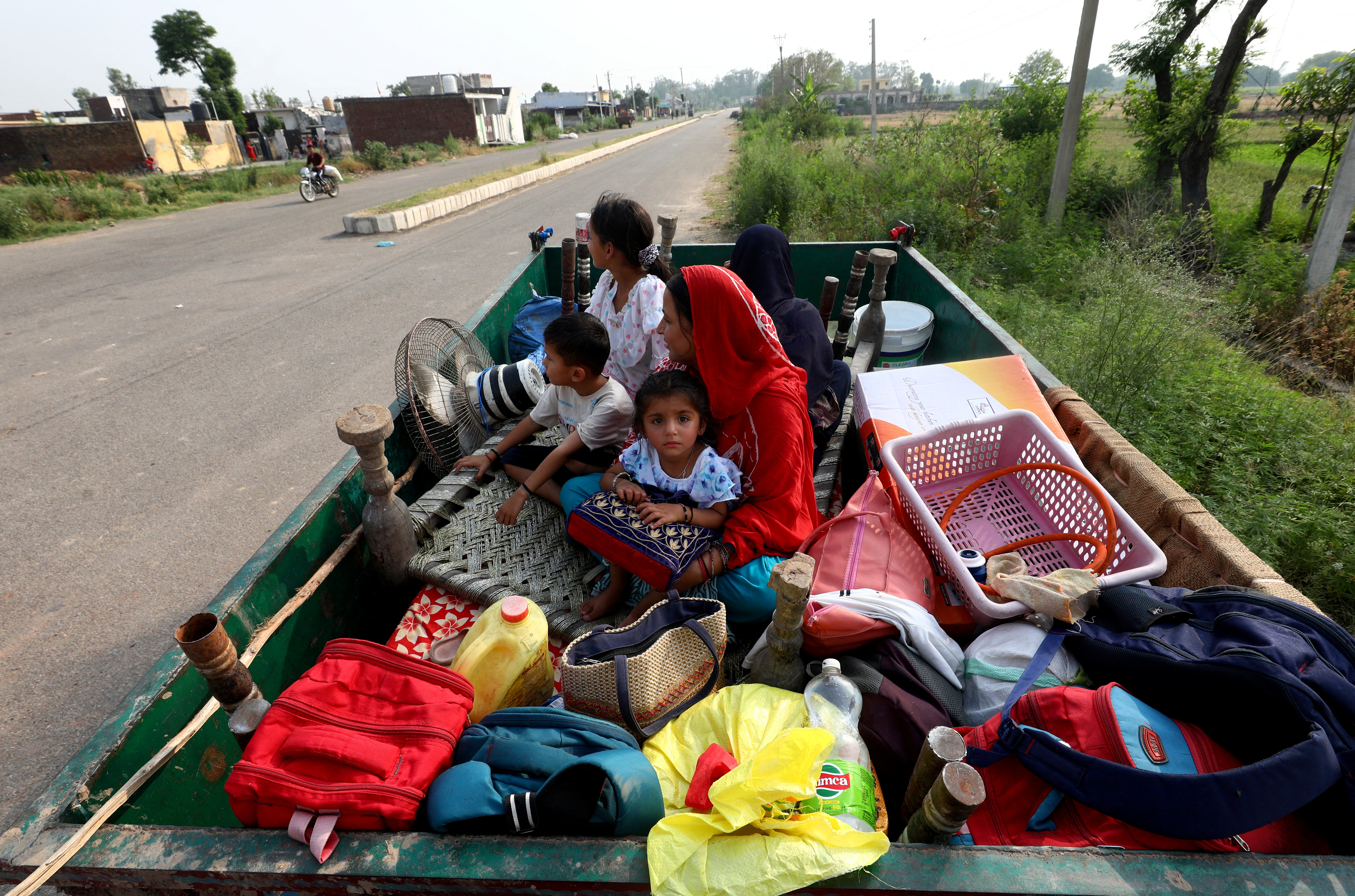 Villagers sit in a tractor trolley as they move to safer places as authorities evacuate residents living near the International Border (IB) with Pakistan, in Suchetgarh, in India-administered Jammu and Kashmir, May 7, 2025. REUTERS/Stringer