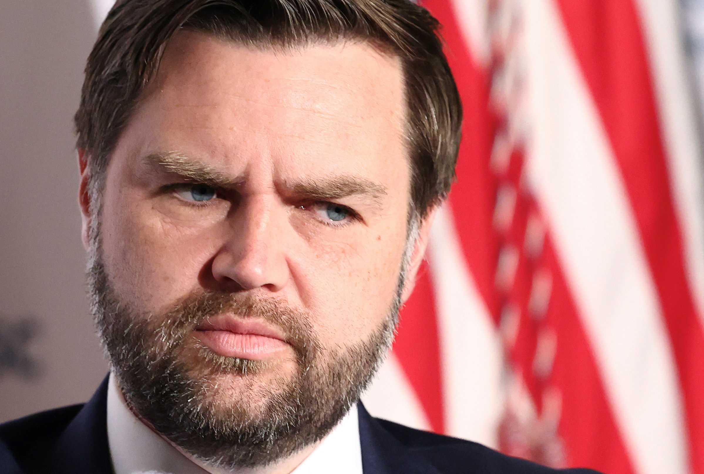 JD Vance in close-up in front of a US flag.