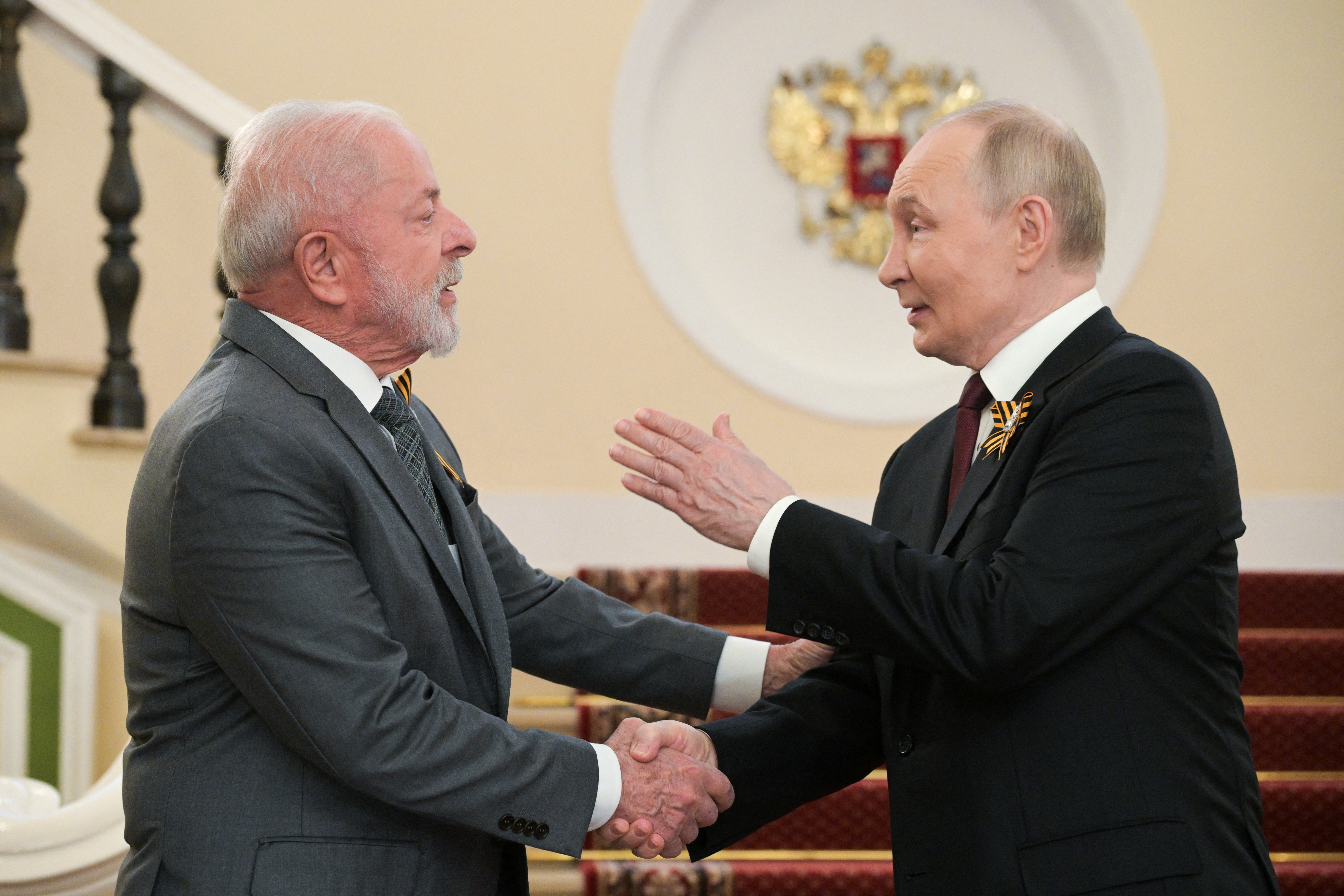 Russian President Vladimir Putin greets Brazilian President Luiz Inacio Lula da Silva.