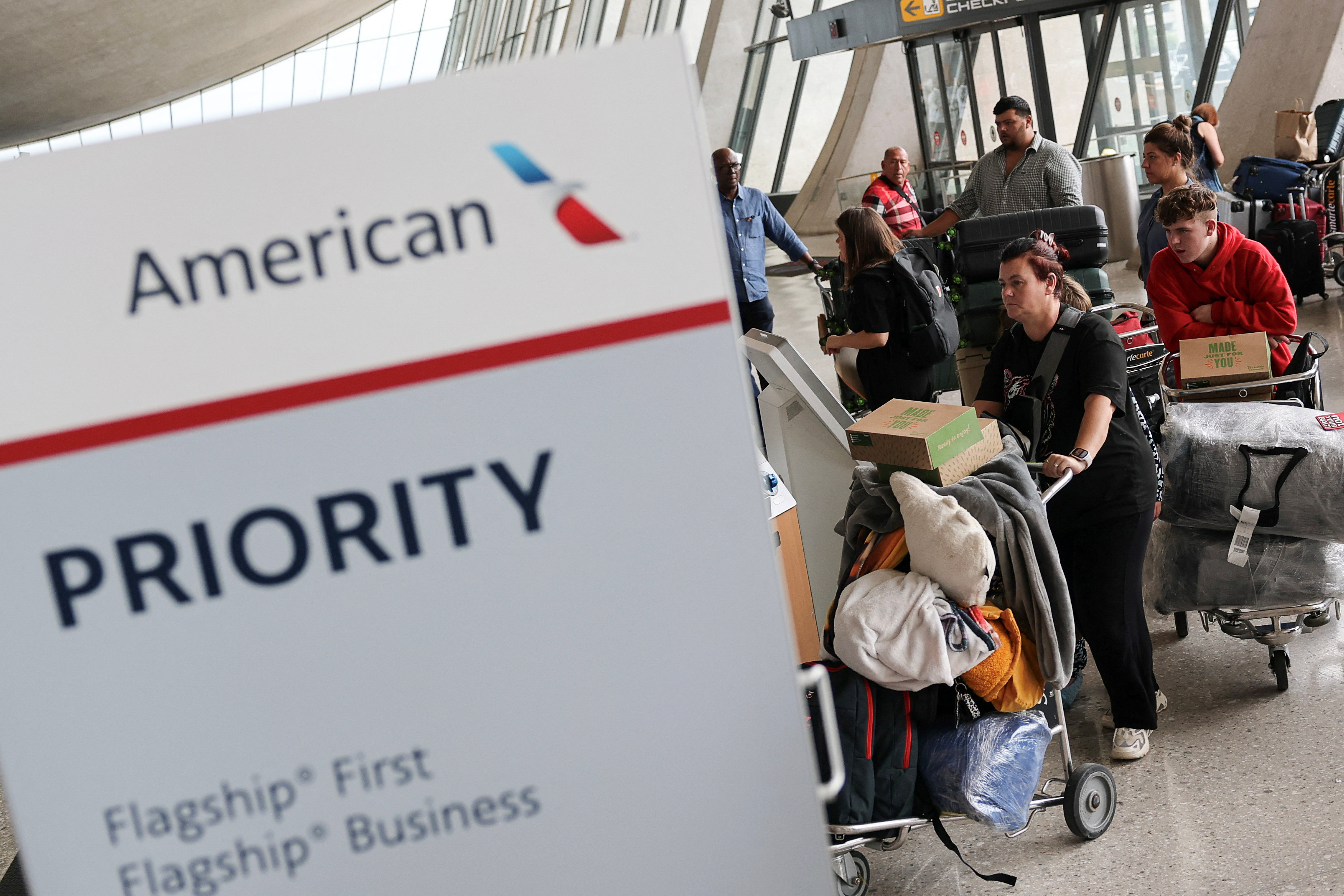 People from the first group of white South Africans granted refugee status for being deemed victims of racial discrimination under U.S. President Trump's Refugee plan, check in for a connecting flight, at Dulles International Airport, in Dulles, Virginia, U.S., May 12, 2025. [Jonathan Ernst/Reuters]