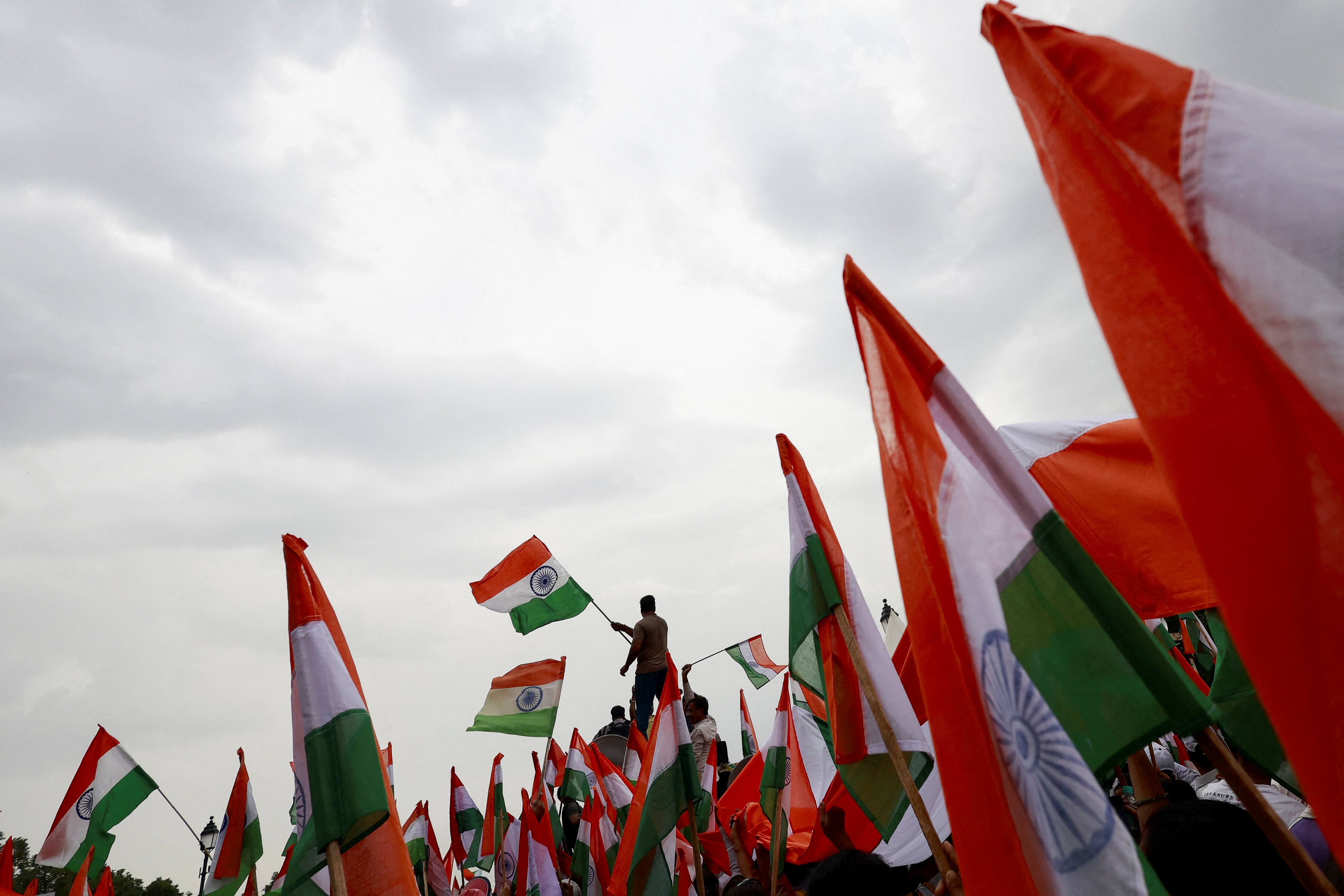 People wave Indian flags in support of the Indian Armed Forces, following the ceasefire announcement between India and Pakistan, in Delhi, India, May 13, 2025. REUTERS/Priyanshu Singh