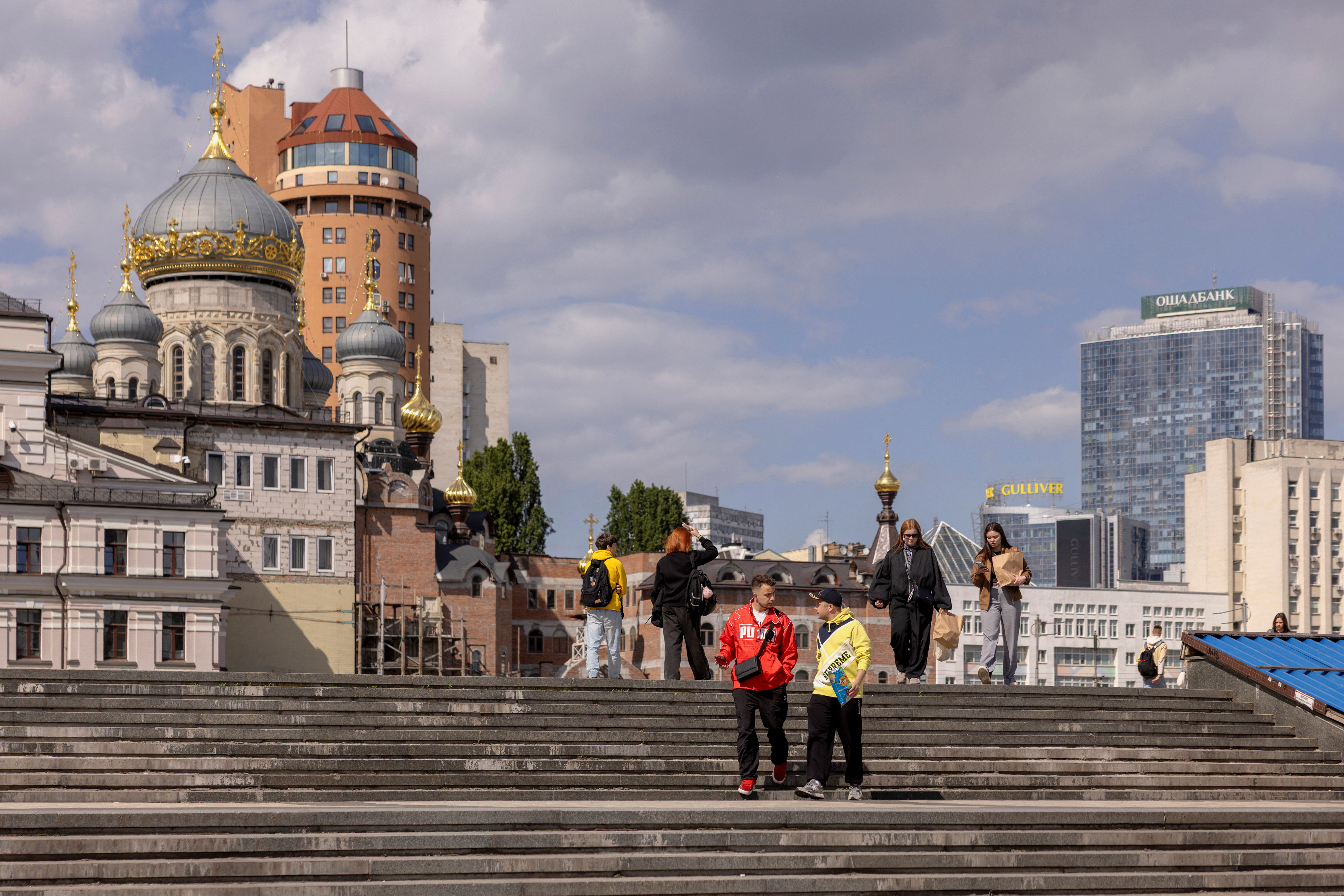 People walk across a square outside the National Sports Complex "Olympiyskiy",
