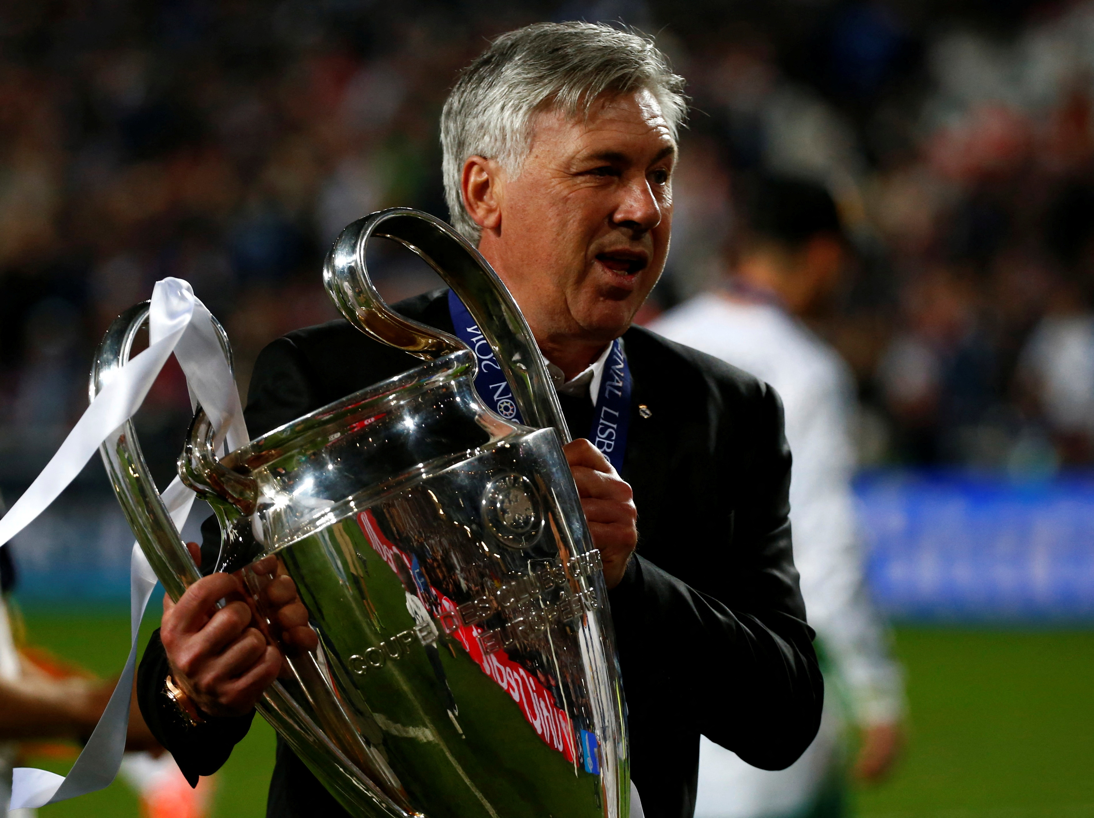 Real Madrid's coach Carlo Ancelotti holds the trophy after defeating Atletico Madrid in their Champions League final soccer match at the Luz Stadium in Lisbon, May 24, 2014
