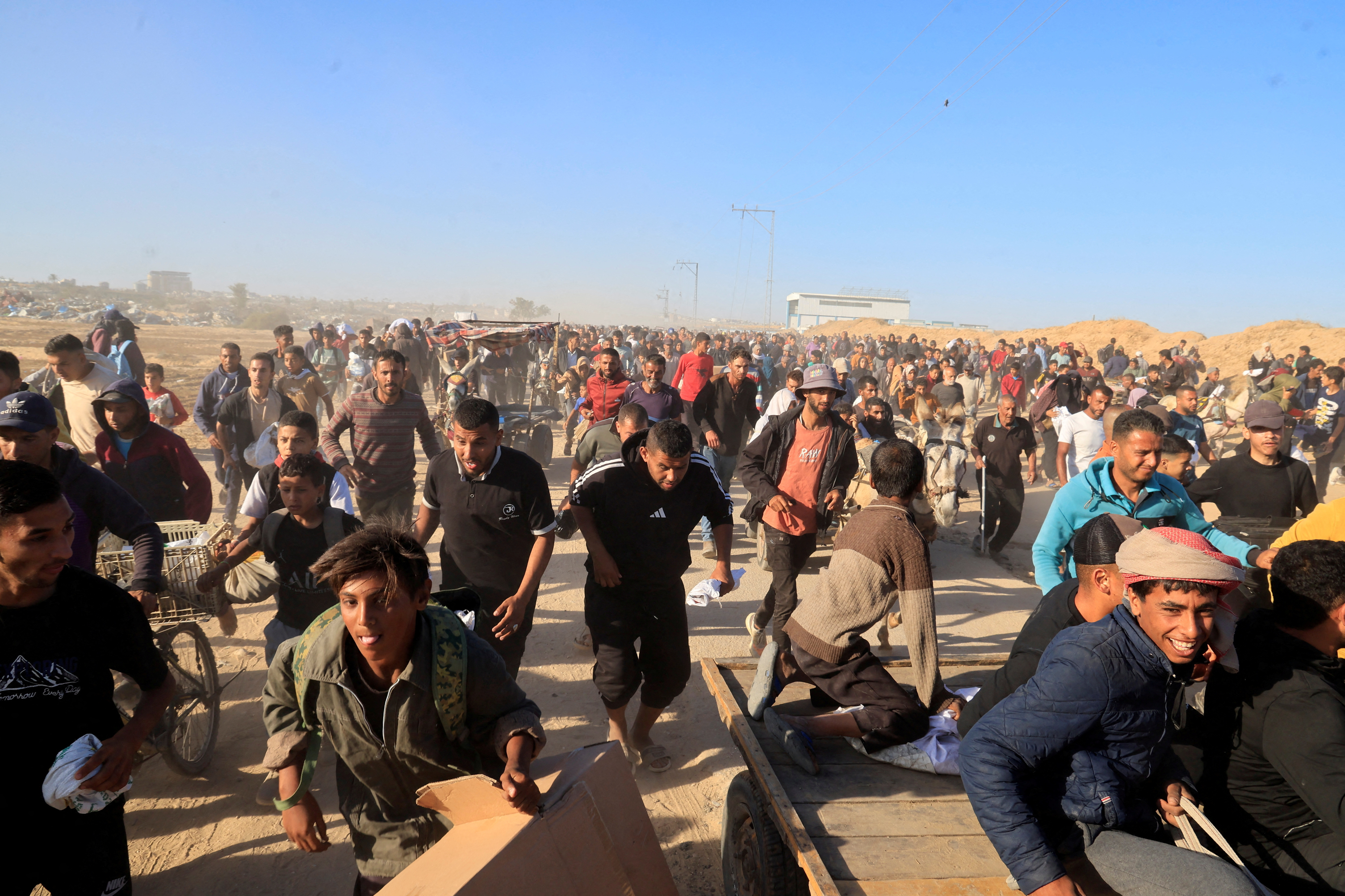 Palestinians run as they gather to collect aid supplies from the U.S.-backed Gaza Humanitarian Foundation, in Khan Younis, in the southern Gaza Strip