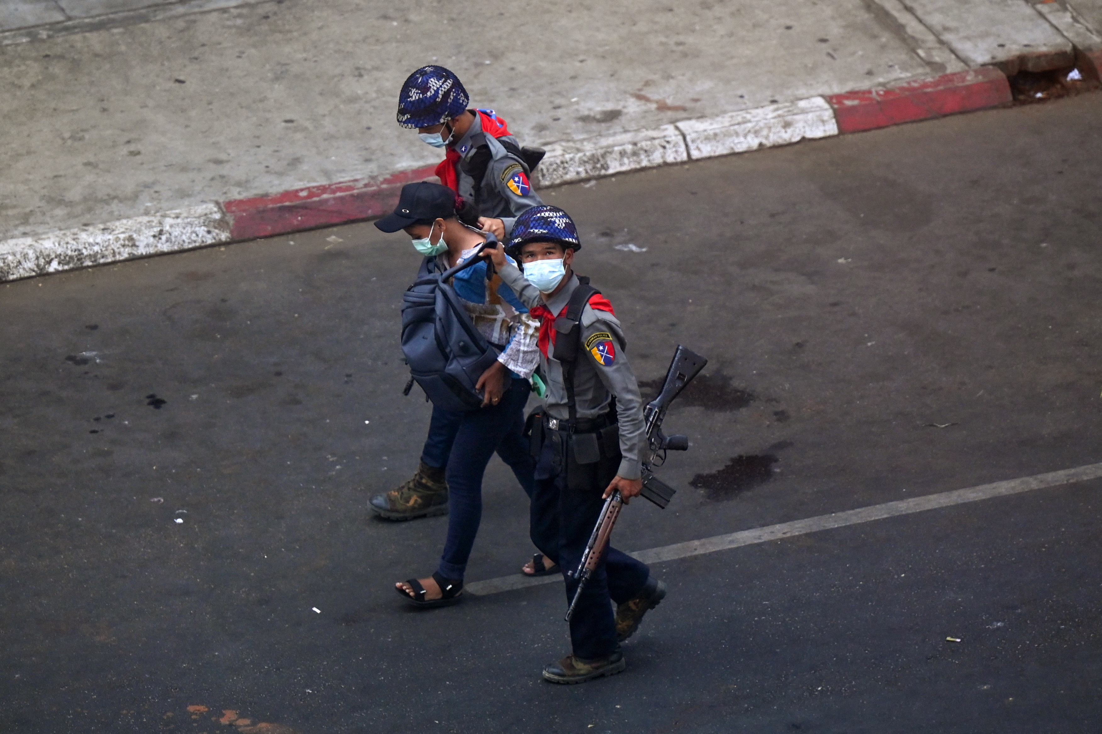 Police arrest Myanmar Now journalist Kay Zon Nwe in Yangon on February 27, 2021, as protesters were taking part in a demonstration against the military coup. (Photo by Ye Aung THU / AFP)