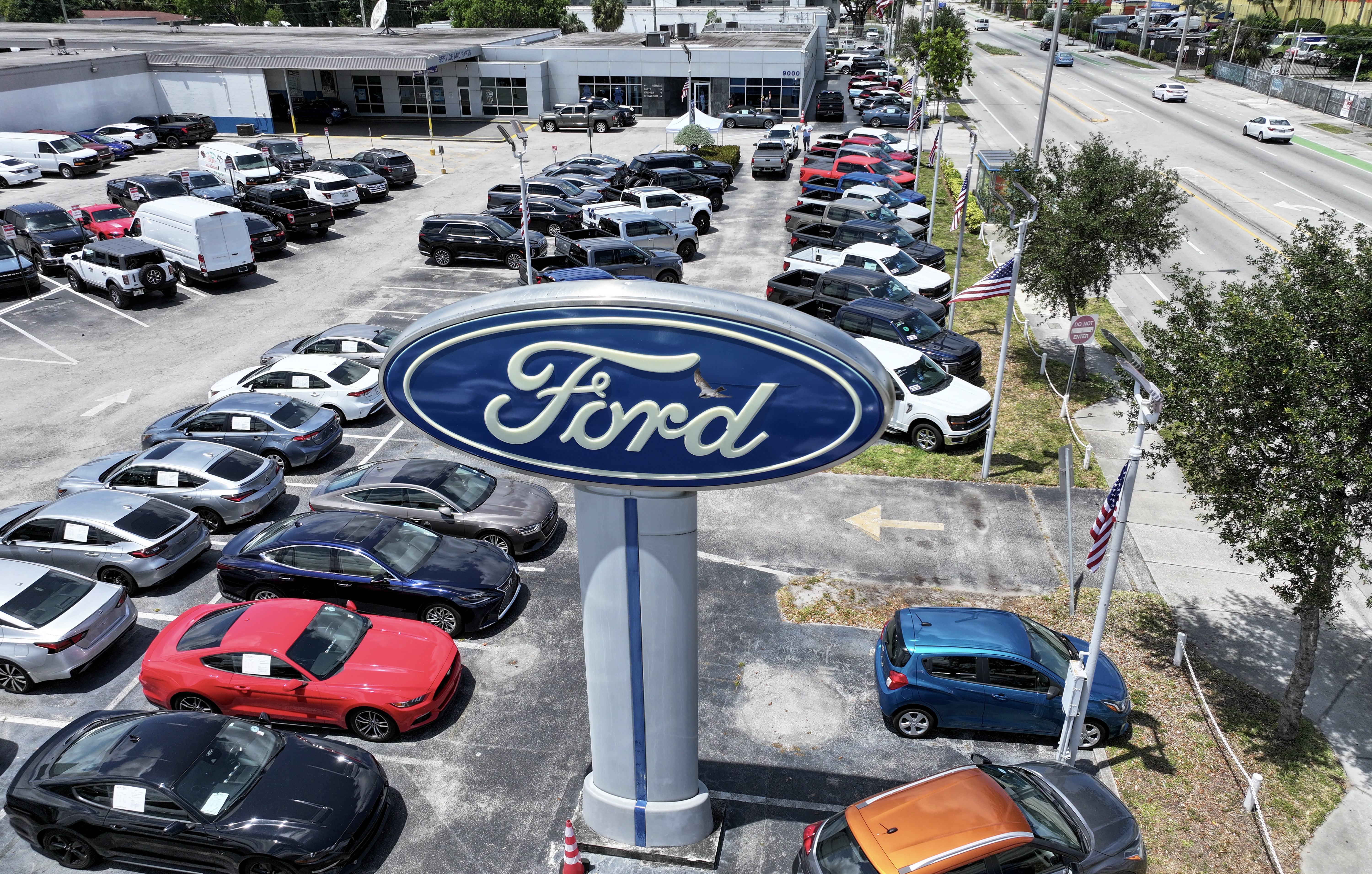 MIAMI, FLORIDA - MAY 06: An aerial view as a Ford sign stands on the sales lot of the Metro Ford dealership on May 06, 2025 in Miami, Florida. Ford Motor Co. pulled its 2025 guidance and said it expects a tariff hit of about $1.5 billion for the year as U.S. automakers face economic uncertainty. Joe Raedle/Getty Images/AFP (Photo by JOE RAEDLE / GETTY IMAGES NORTH AMERICA / Getty Images via AFP)