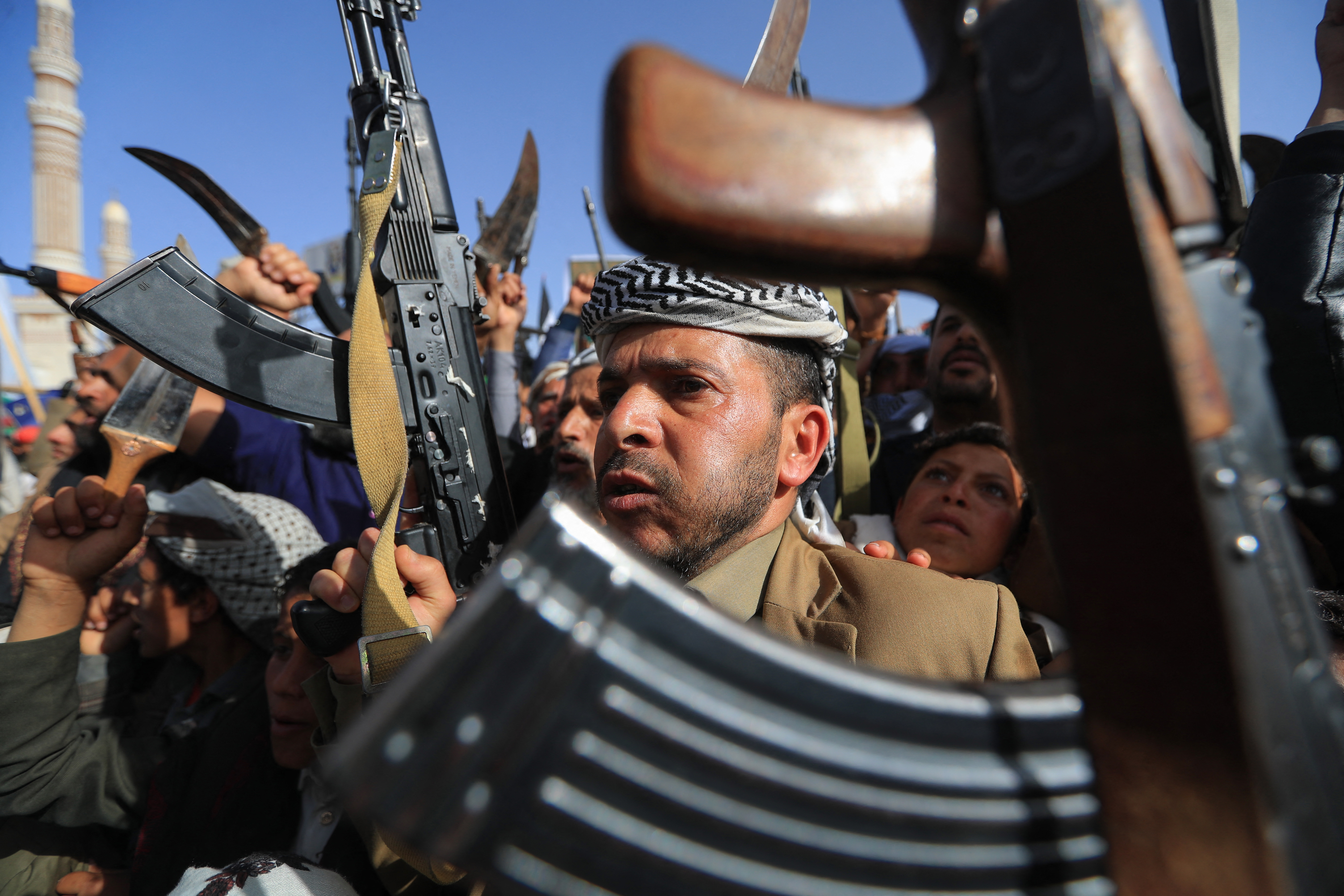 Yemenis brandish rifles in the Houthi-run capital Sanaa