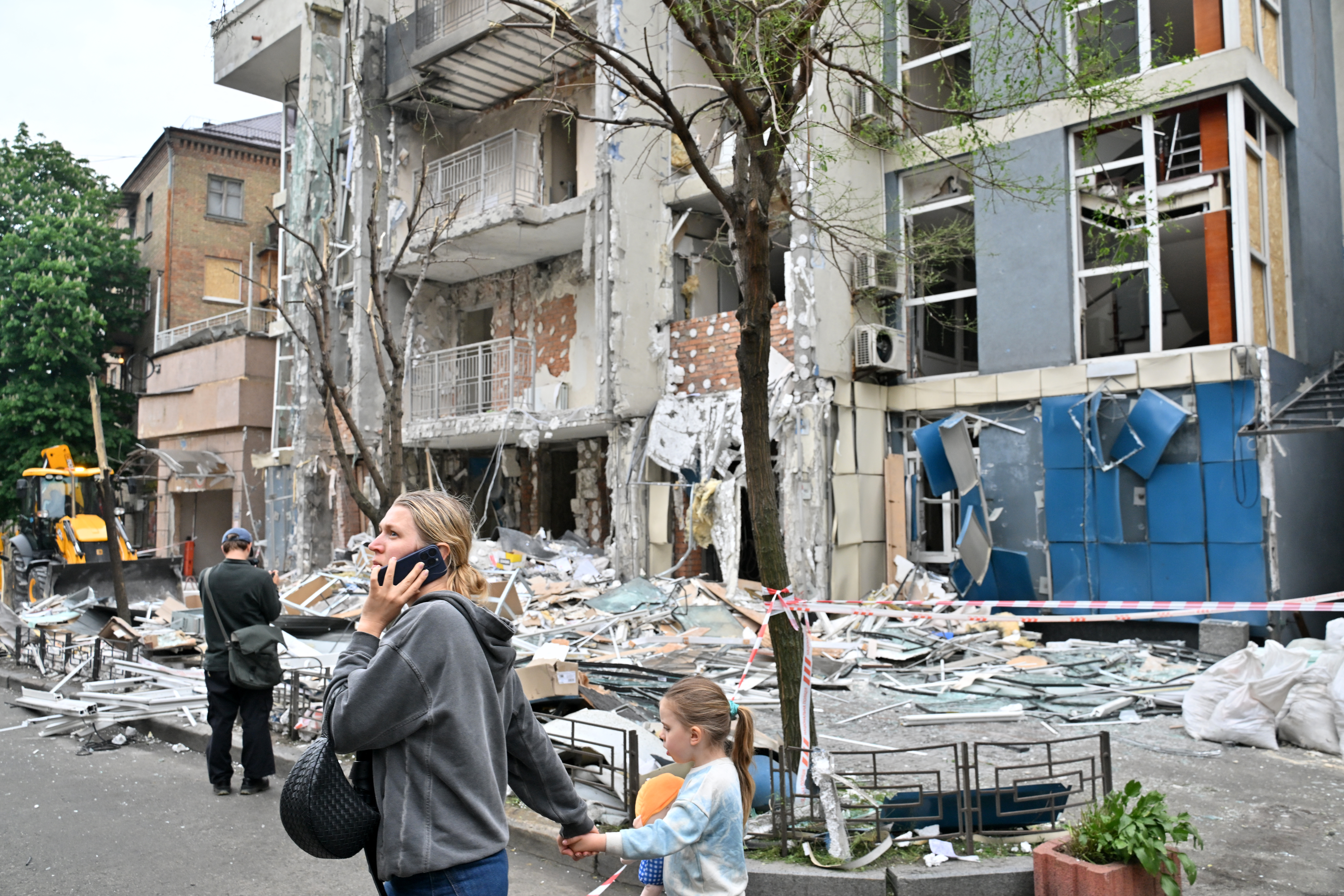 People walk past a multistory residential building damaged following a drone strike in Kyiv on May 25, 2025, amid Russian invasion in Ukraine. Russia launched a record number of drones against Ukraine and killed 12 people across the country, officials said on May 25, even as Kyiv and Moscow completed their biggest prisoner exchange since the start of the war. (Photo by Sergei SUPINSKY / AFP)