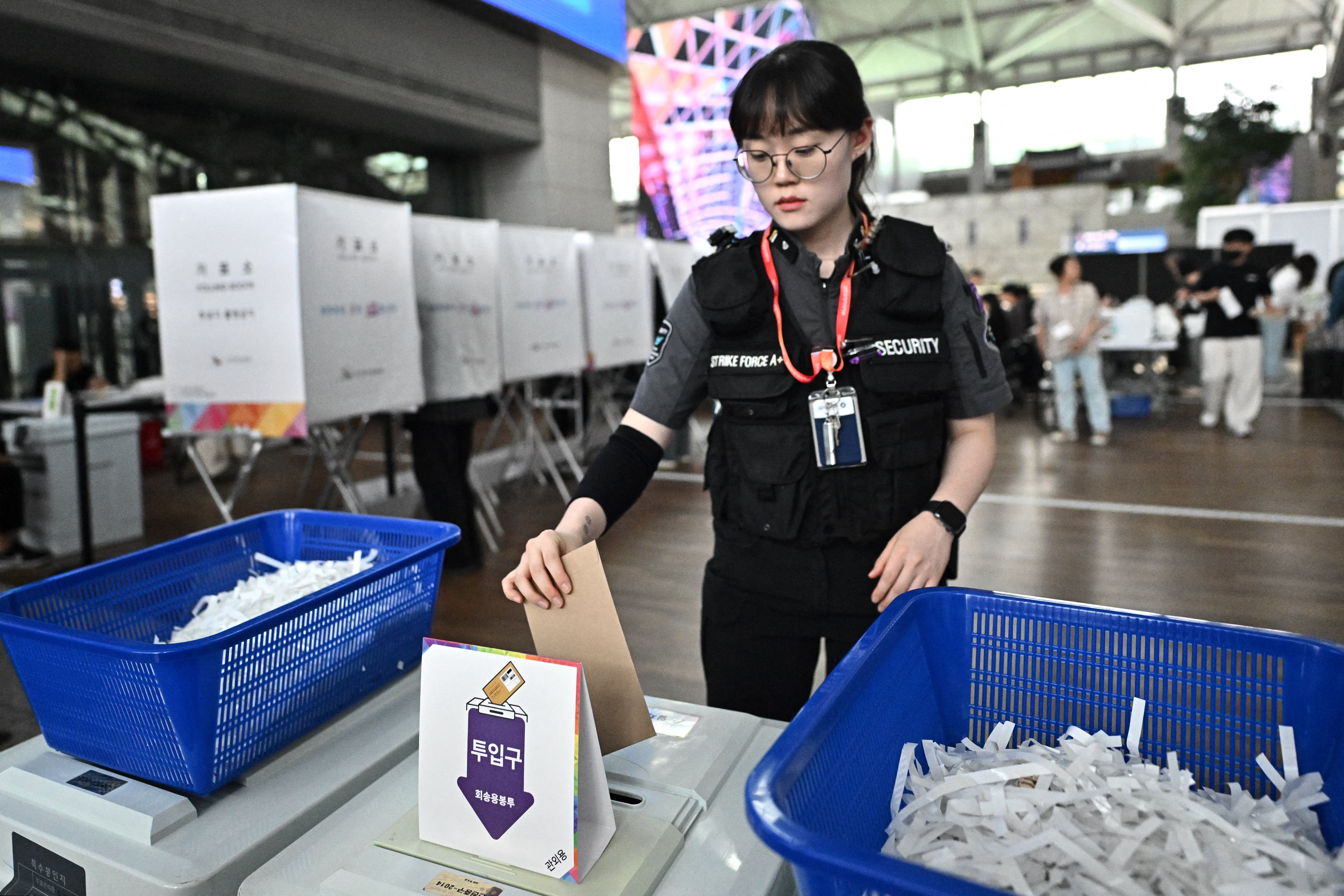 A woman votes at a polling station installed in the departures area of the Incheon International Airport during early voting of the presidential election in Incheon on May 29, 2025. (Photo by Pedro Pardo / AFP)