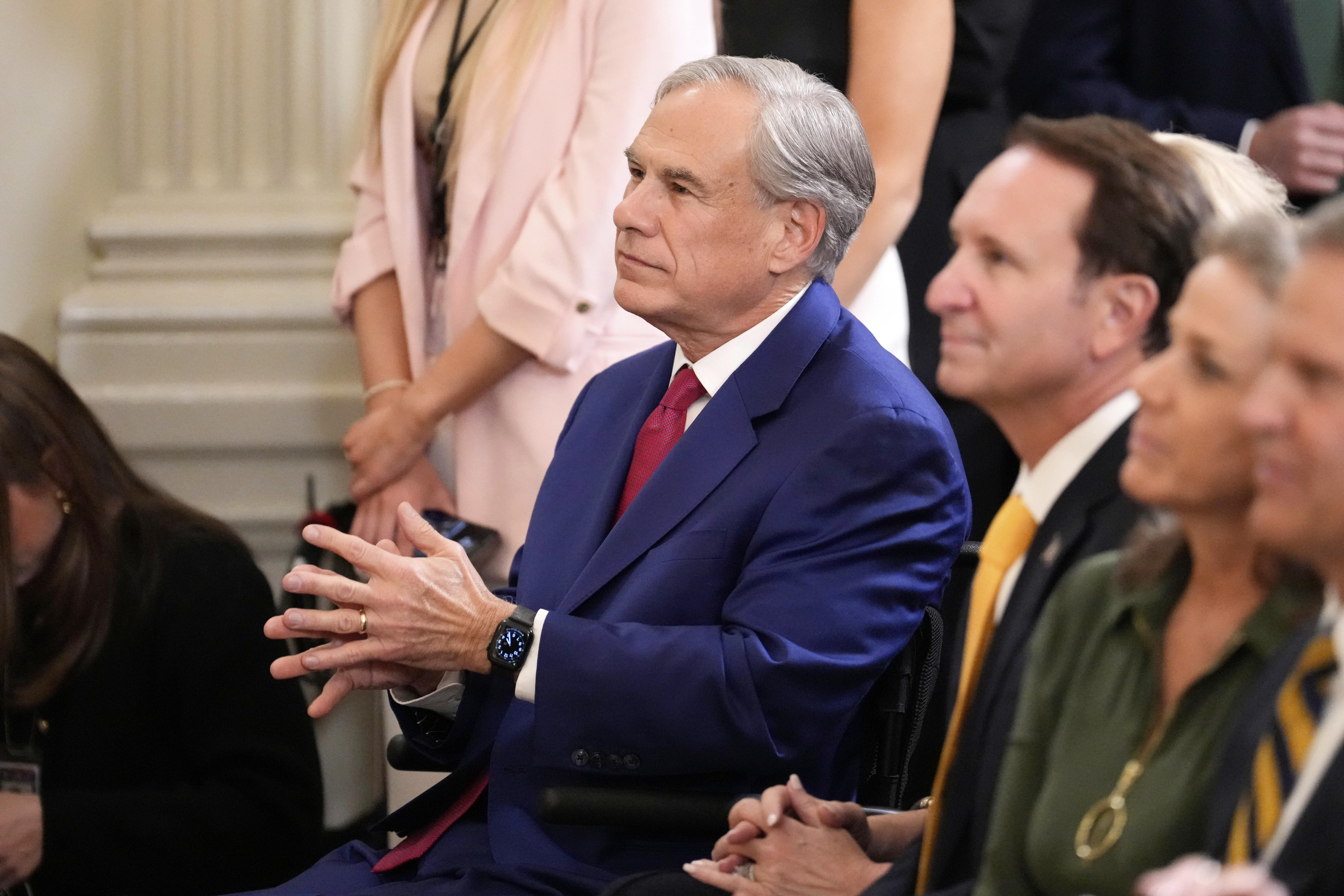 Texas Gov. Greg Abbott sits before President Donald Trump arrives to speak at an education event and executive order signing in the East Room of the White House in Washington, Thursday, March 20, 2025. (AP Photo/Ben Curtis)