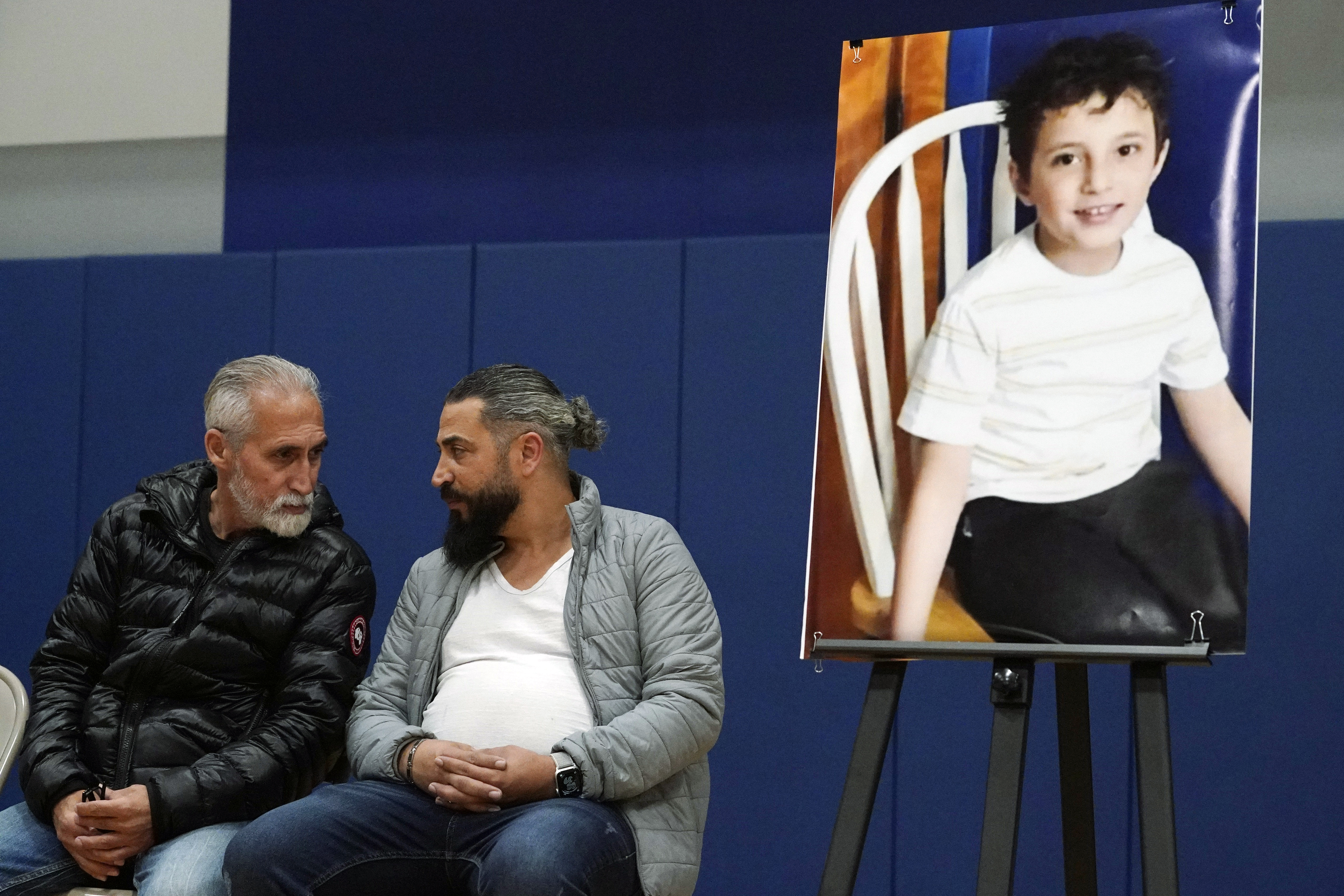 Oday Al Fayoume sits beneath a portrait of his slain 6-year-old son.