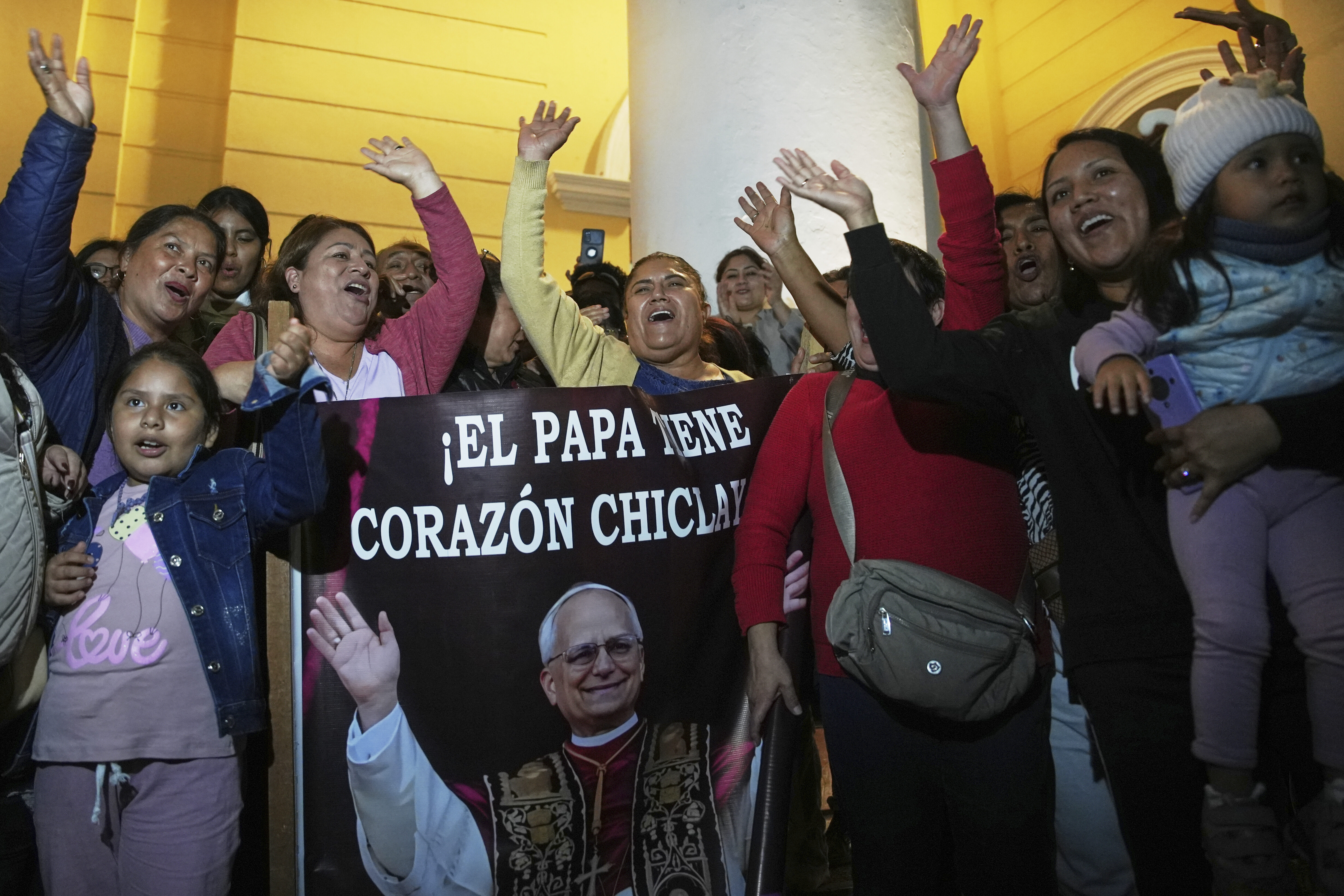 Parishioners hold up a banner that says in Spanish, "The pope has a Chiclayano heart."