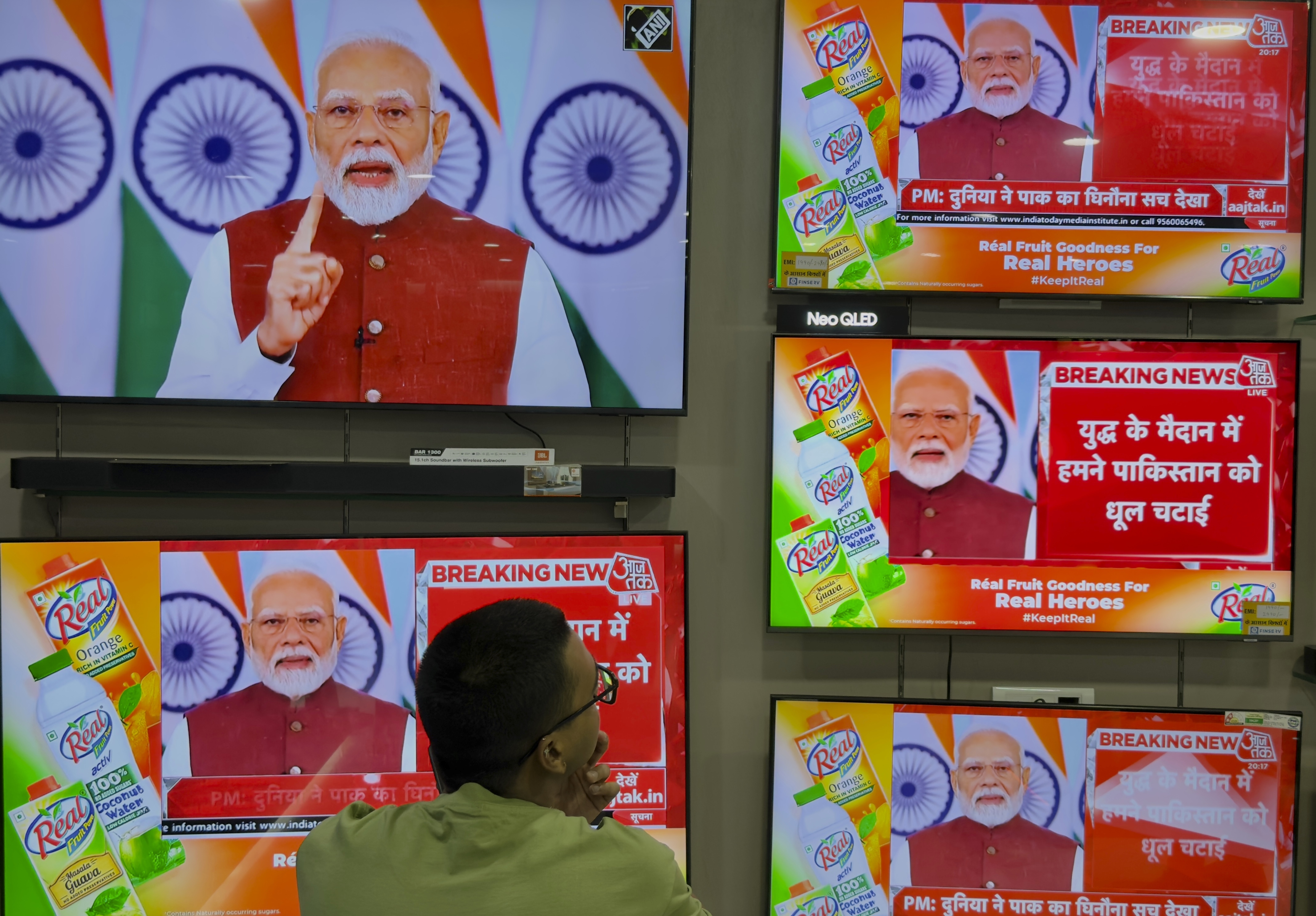 An Indian man watches the live telecast of Indian Prime Minister Narendra Modi's speech on television screens, in Prayagraj, in the northern Indian state of Uttar Pradesh, India, Monday, May 12, 2025. (AP Photo/Rajesh Kumar Singh)