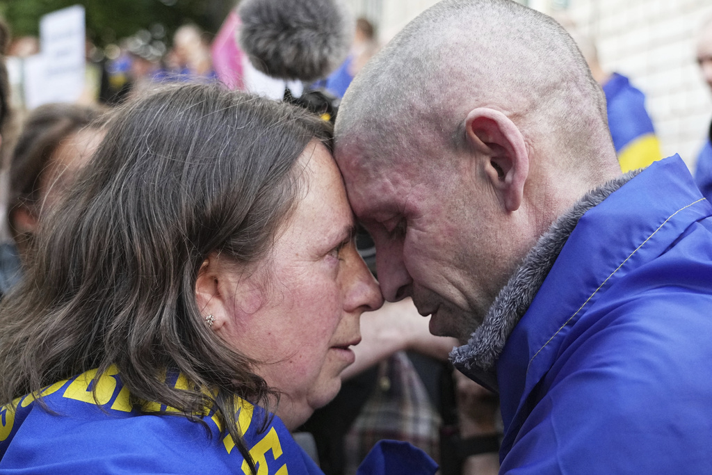 A Ukrainian serviceman hugs his wife after returning from captivity