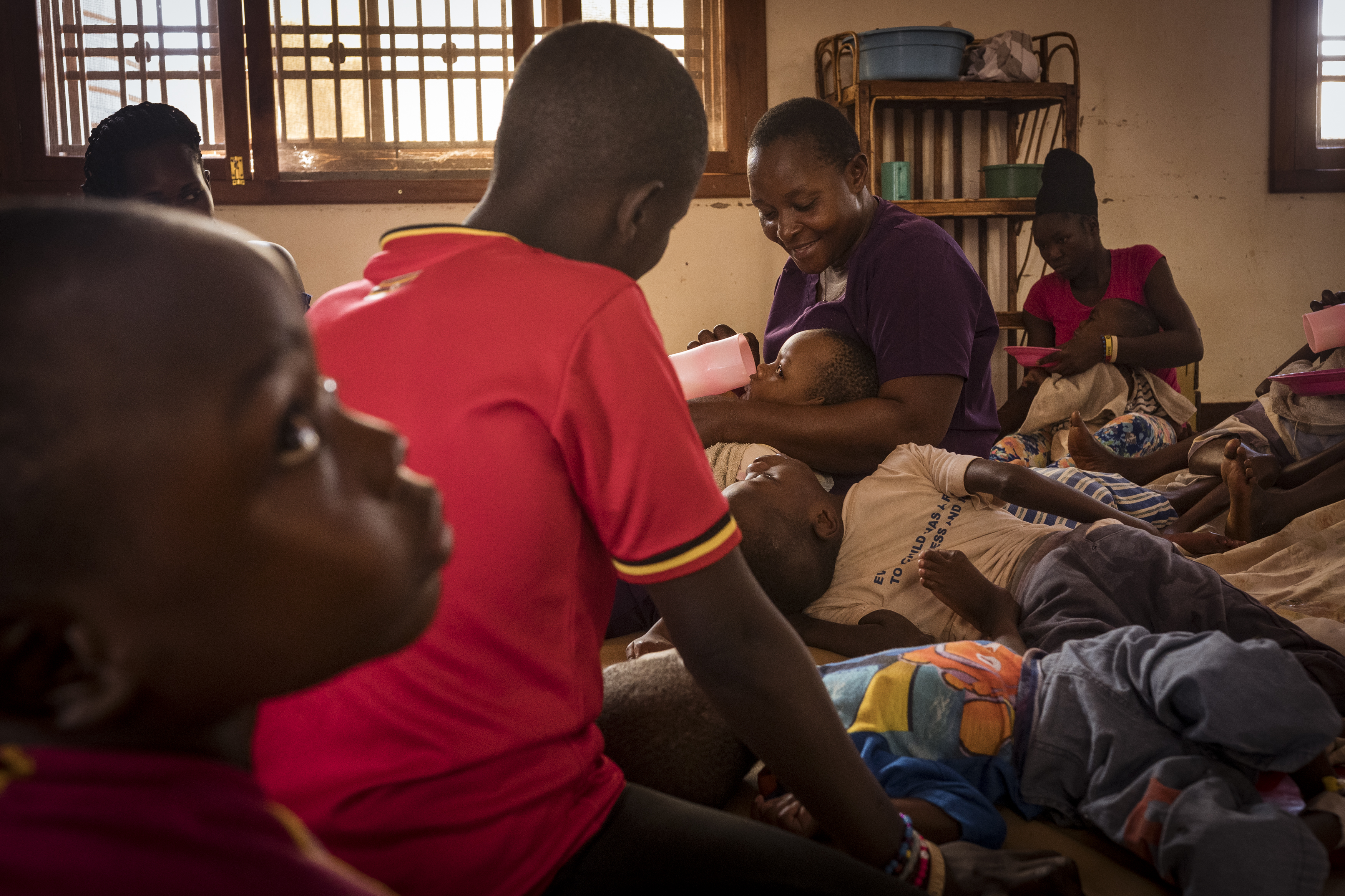 Bugembe, Jinja District, Uganda. Home of Hope founder and director Edith Lukabwe feeds orphaned children at Home of Hope therapy room. [Christopher Hopkins/Al Jazeera]