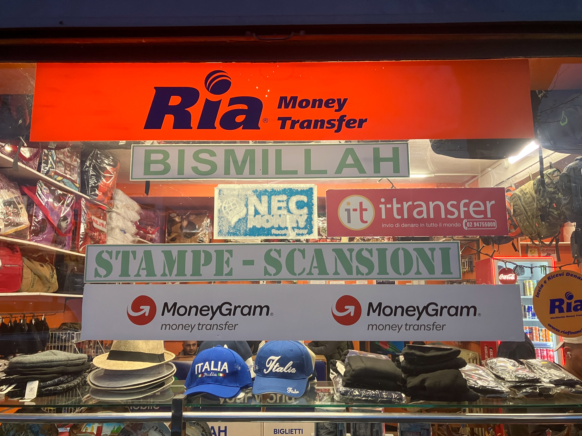 A storefront in Mestre shows the different types of services available for immigrant communities sending money back home. [Michela Moscufo/Al Jazeera]