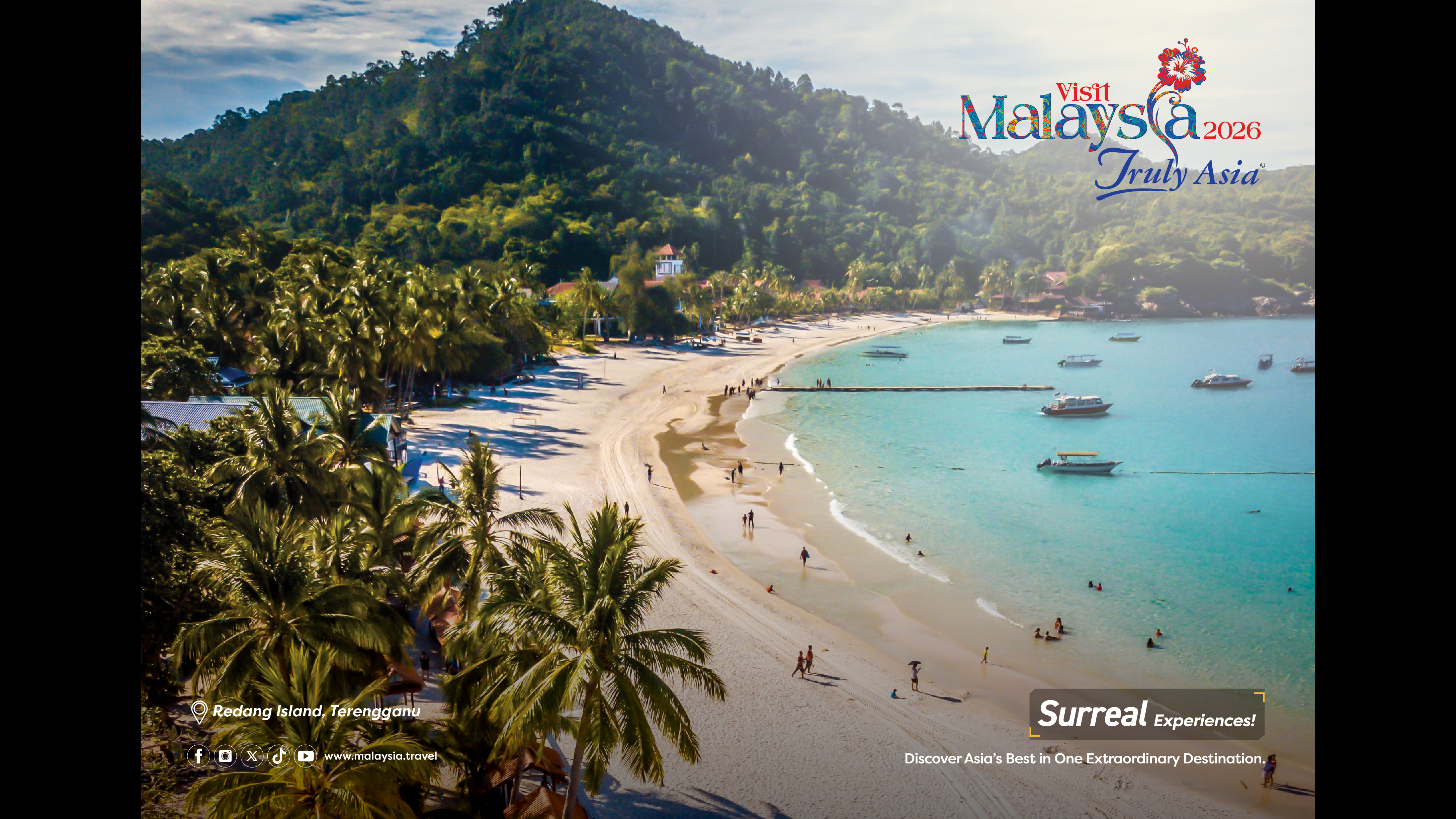 A golden sand beach lined by palm trees with a green mountain in the distance