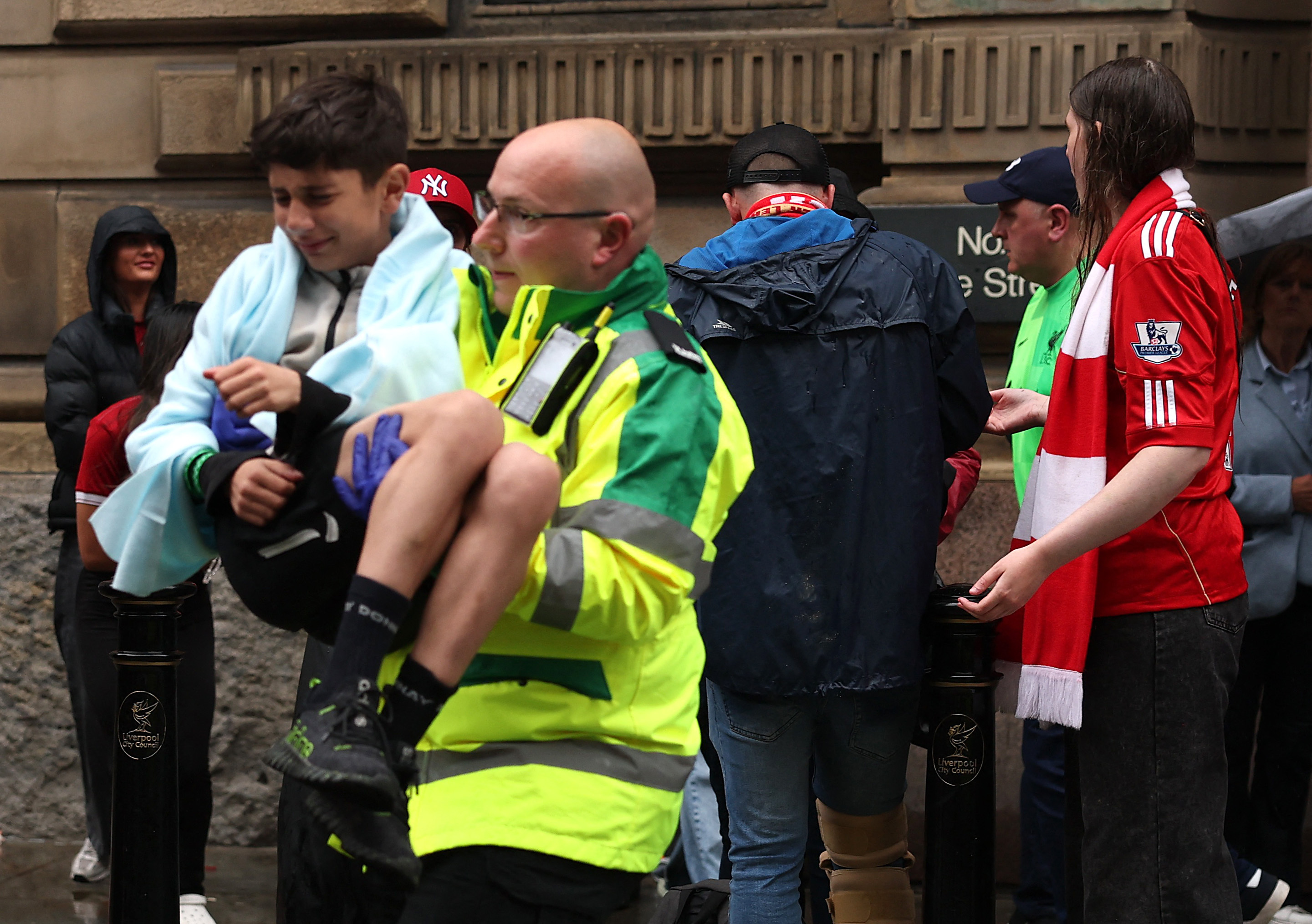 Soccer Football - Premier League - Liverpool Victory Parade - Liverpool, Britain - May 26, 2025 A paramedic carries a child after multiple people were hit by a car during the Victory parade Action Images via Reuters/Lee Smith