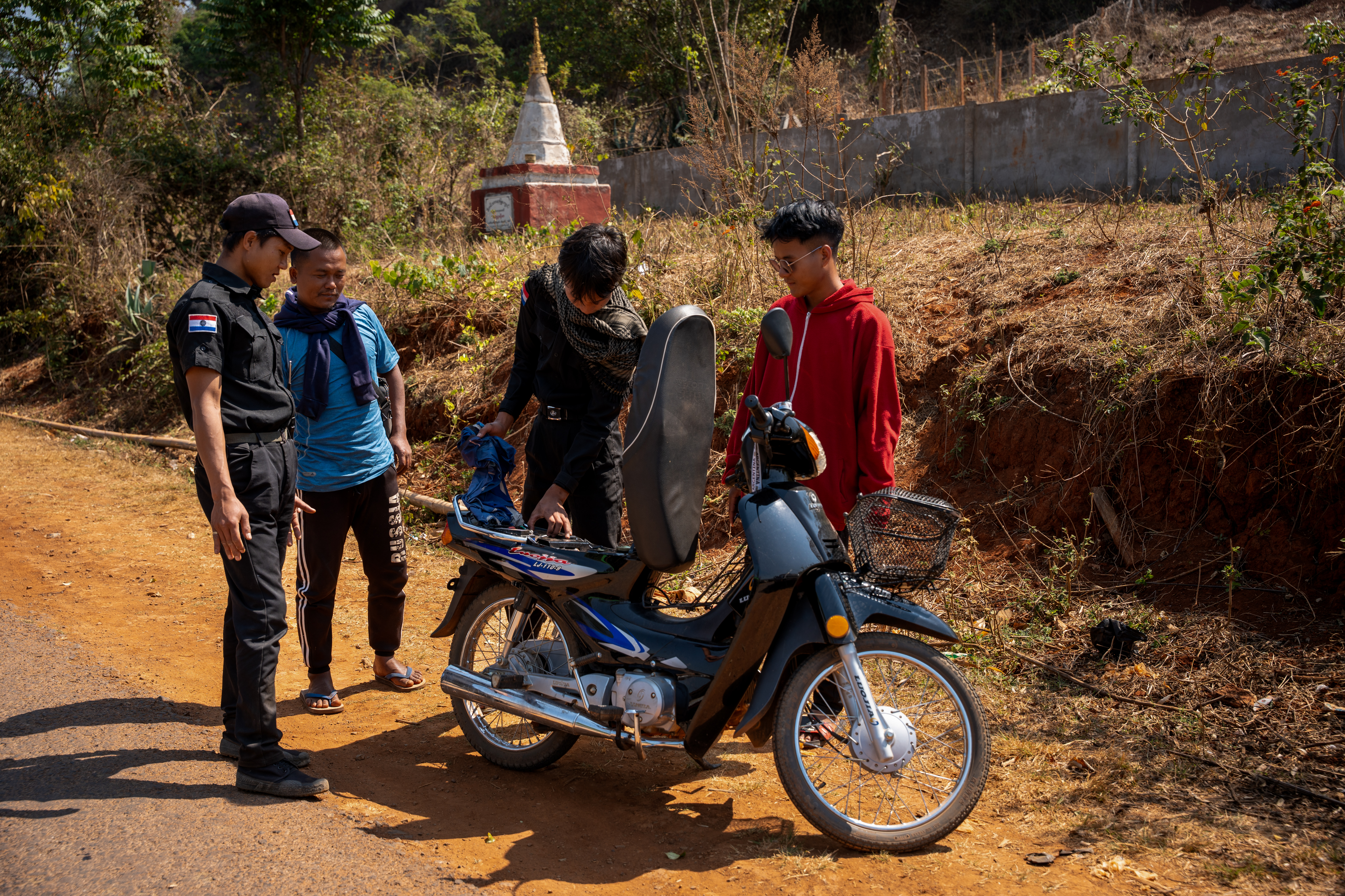 017 – Karenni police officers search a motorbike at a checkpoint in Pekon District.