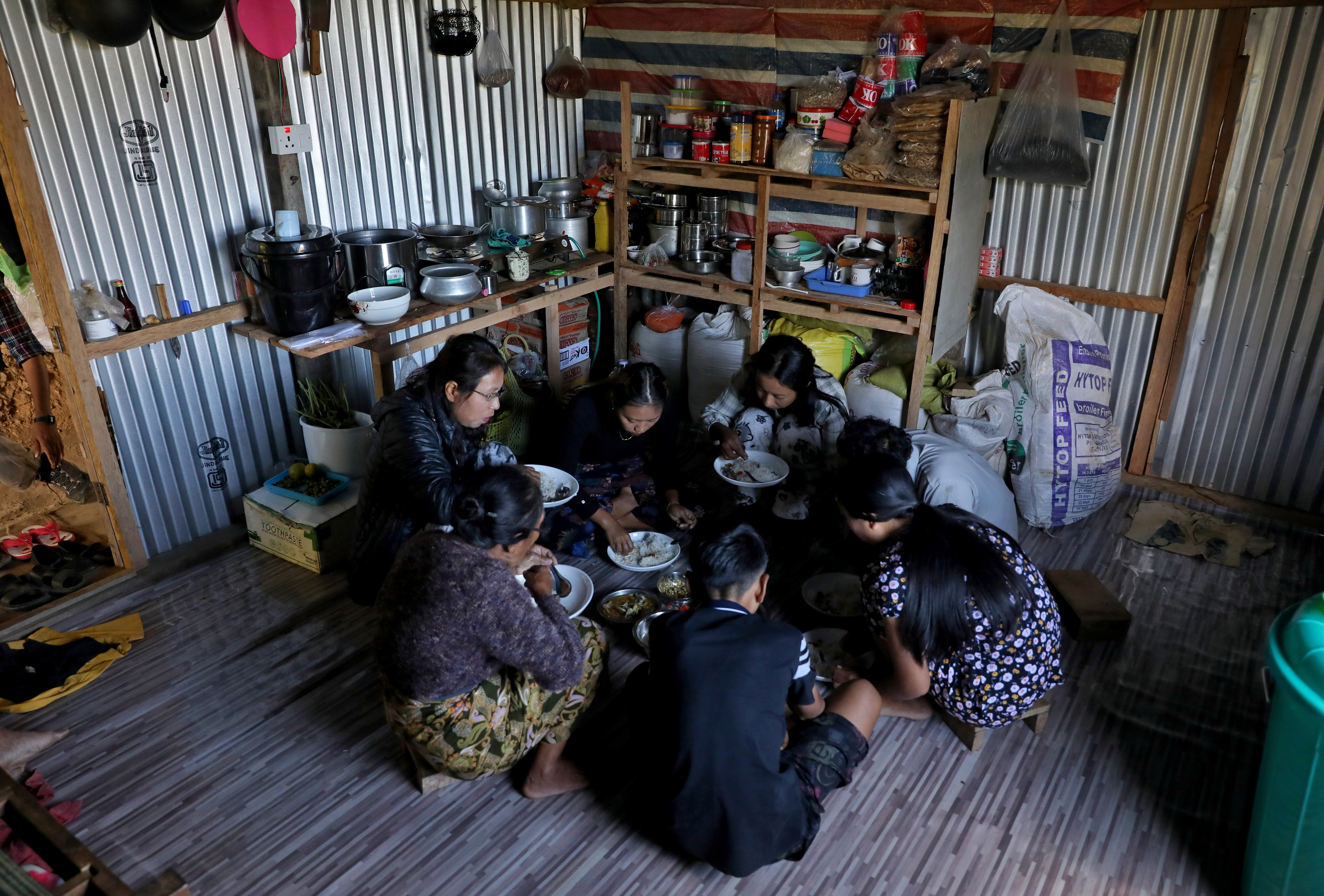 Mah Tial, who fled from Myanmar, eats a meal with her family members inside a house at Farkawn village near the India-Myanmar border, in the northeastern state of Mizoram, India, November 21, 2021. Picture taken November 21, 2021. REUTERS/Rupak De Chowdhuri