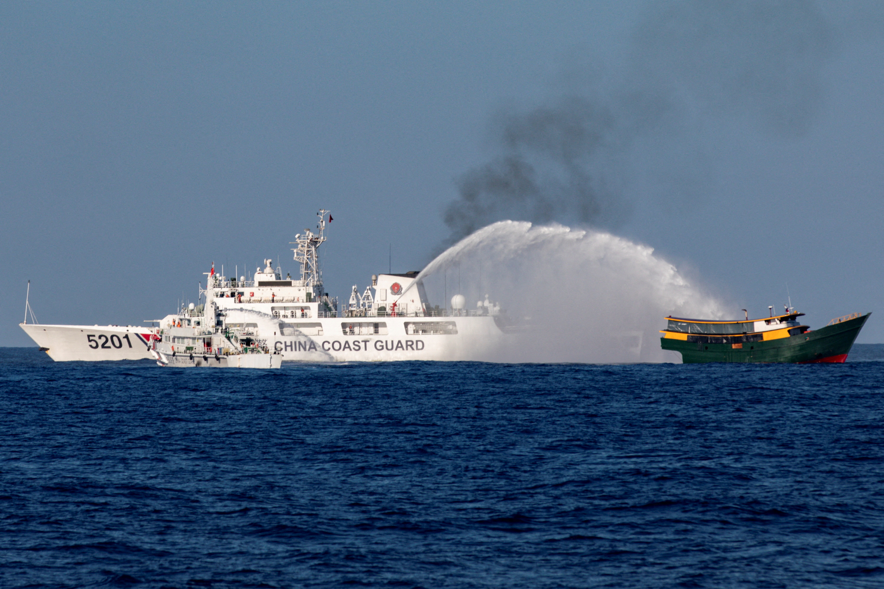 Chinese Coast Guard vessels fire water cannons towards a Philippine resupply vessel Unaizah May 4 on its way to a resupply mission at Second Thomas Shoal in the South China Sea, March 5, 2024. REUTERS/Adrian Portugal TPX IMAGES OF THE DAY