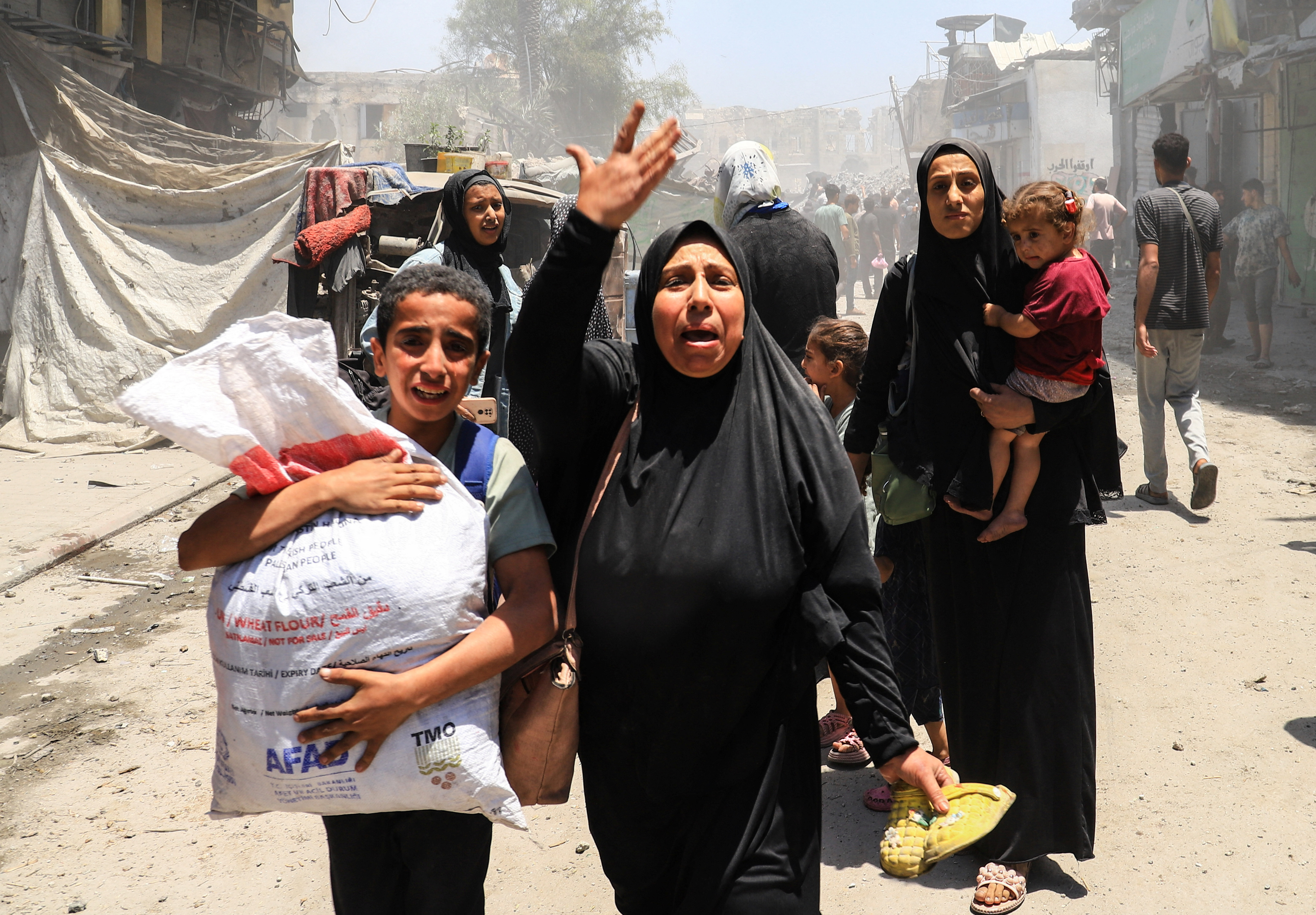 Palestinians evacuate in the aftermath of an Israeli attack on a house in Gaza City