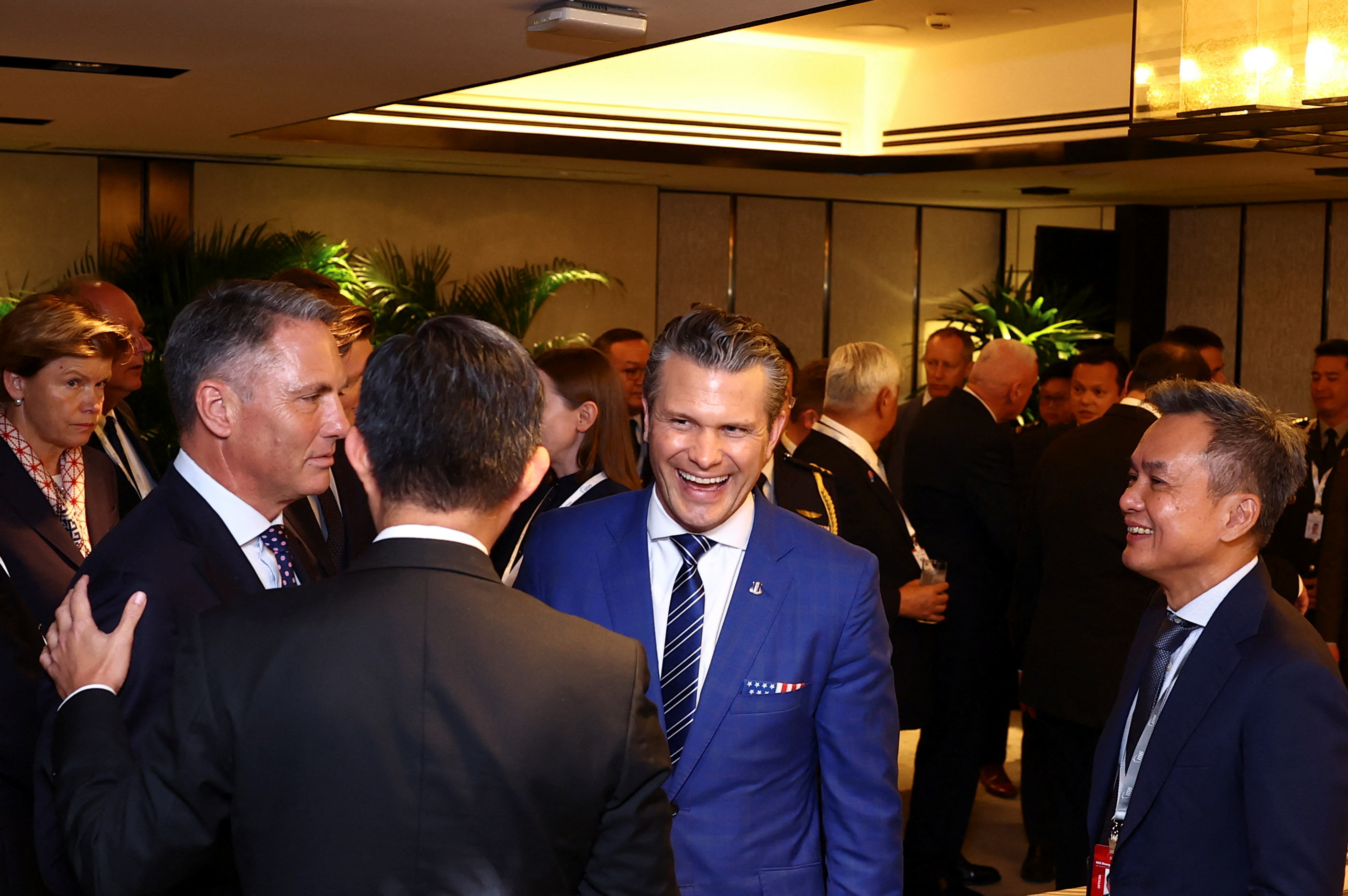 men in suits talk at a reception