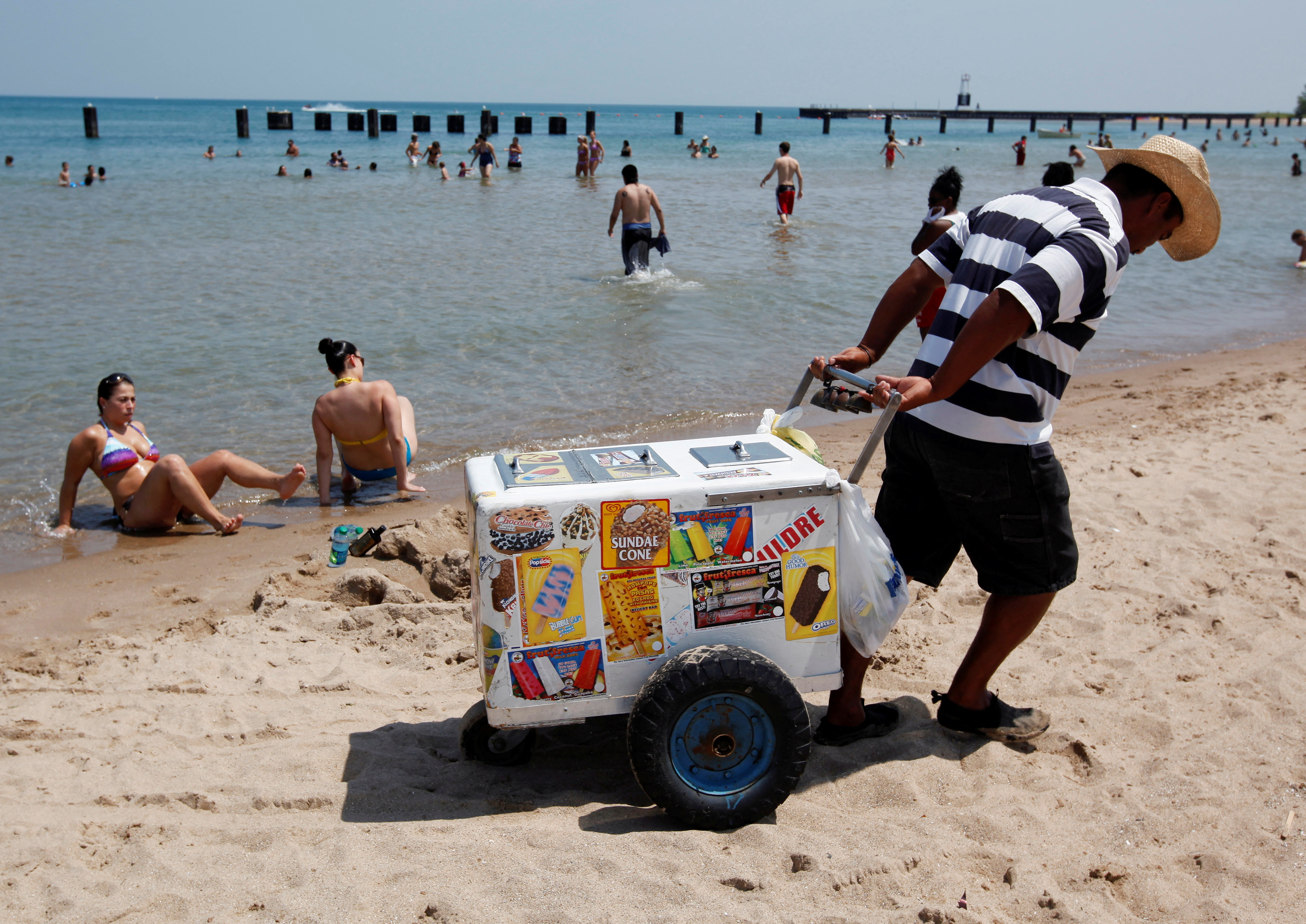 A vendor drags his ice cream cooler across North Avenue Beach in Chicago [File: Jim Young/Reuters]