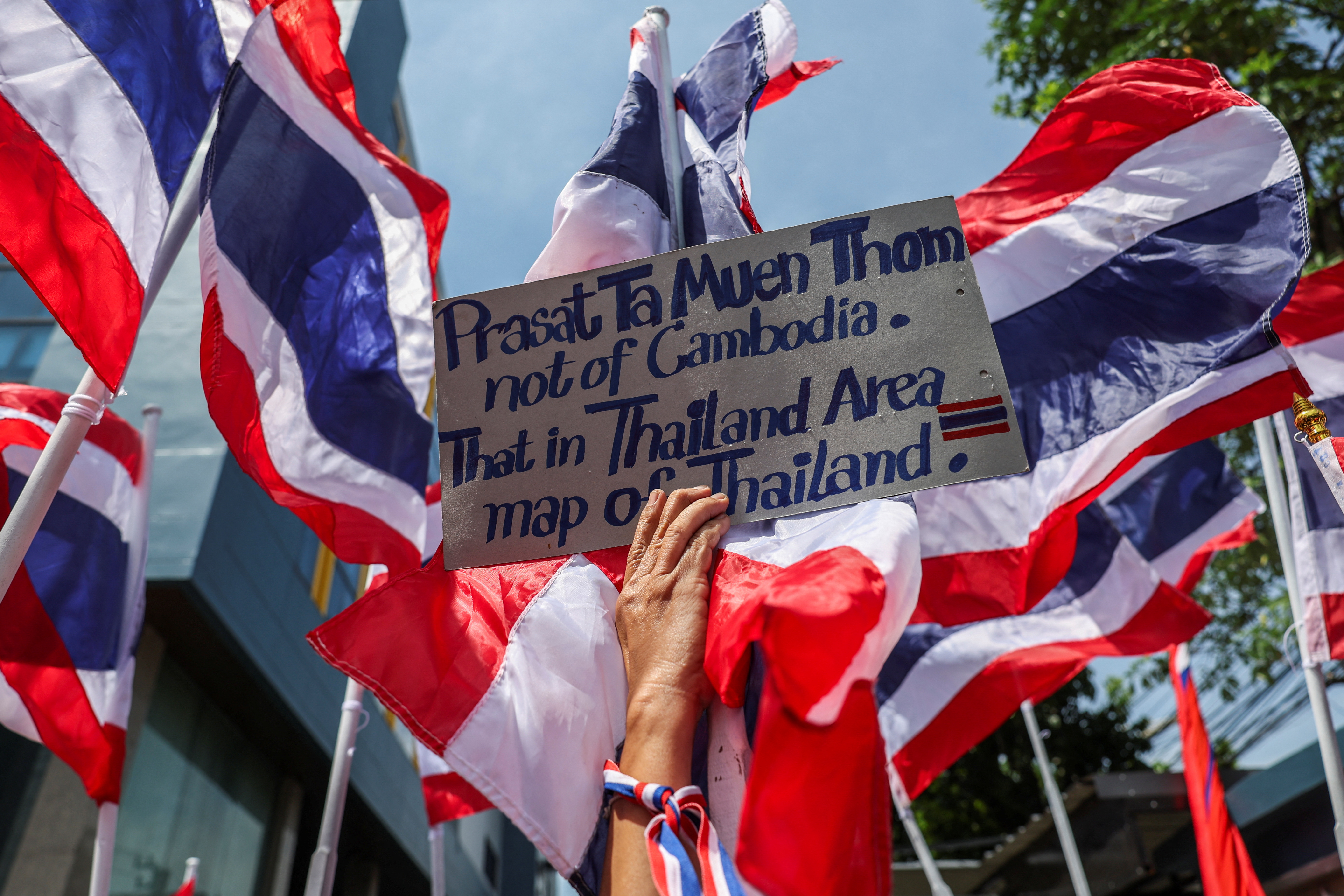 A royalist activist holds a placard as she protests in front of the Royal Embassy of Cambodia,