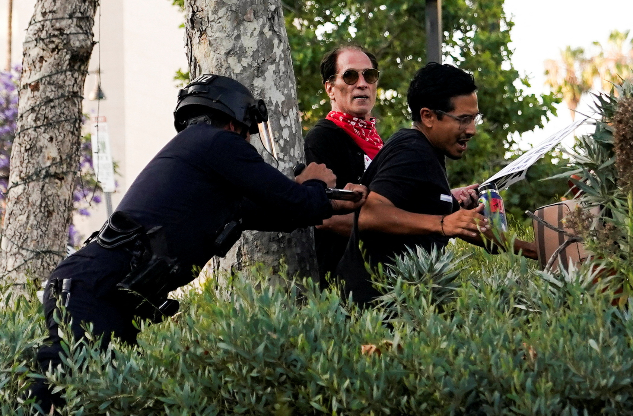A member of law enforcement disperses people as protests against federal immigration sweeps continue, in downtown Los Angeles, California, U.S. June 11, 2025. REUTERS/David Ryder