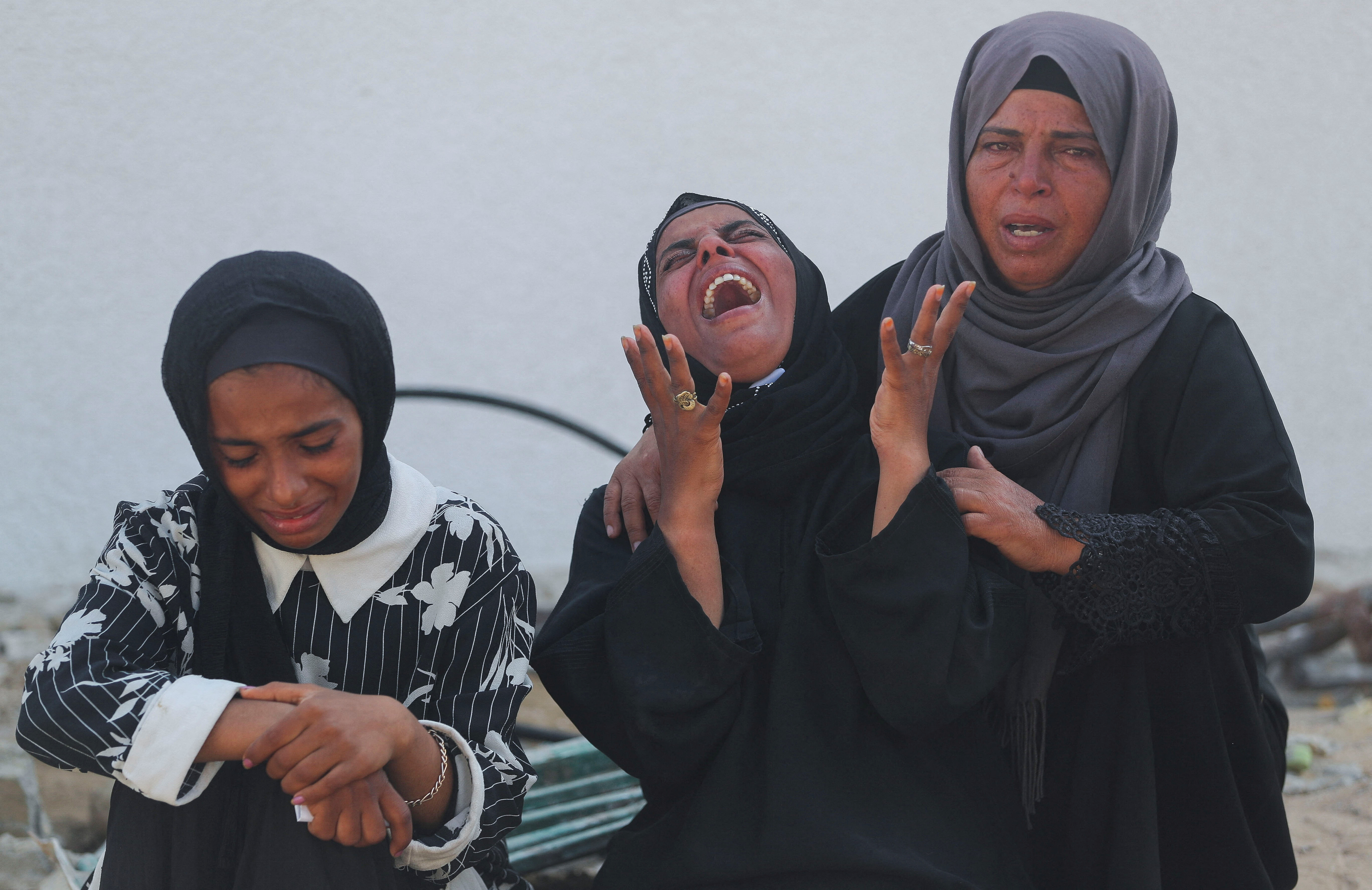 A woman reacts as mourners attend the funeral of Palestinians who were killed, according to medics, in Israeli fire, at Al-Shifa hospital, in Gaza City, June 12, 2025. REUTERS/Mahmoud Issa