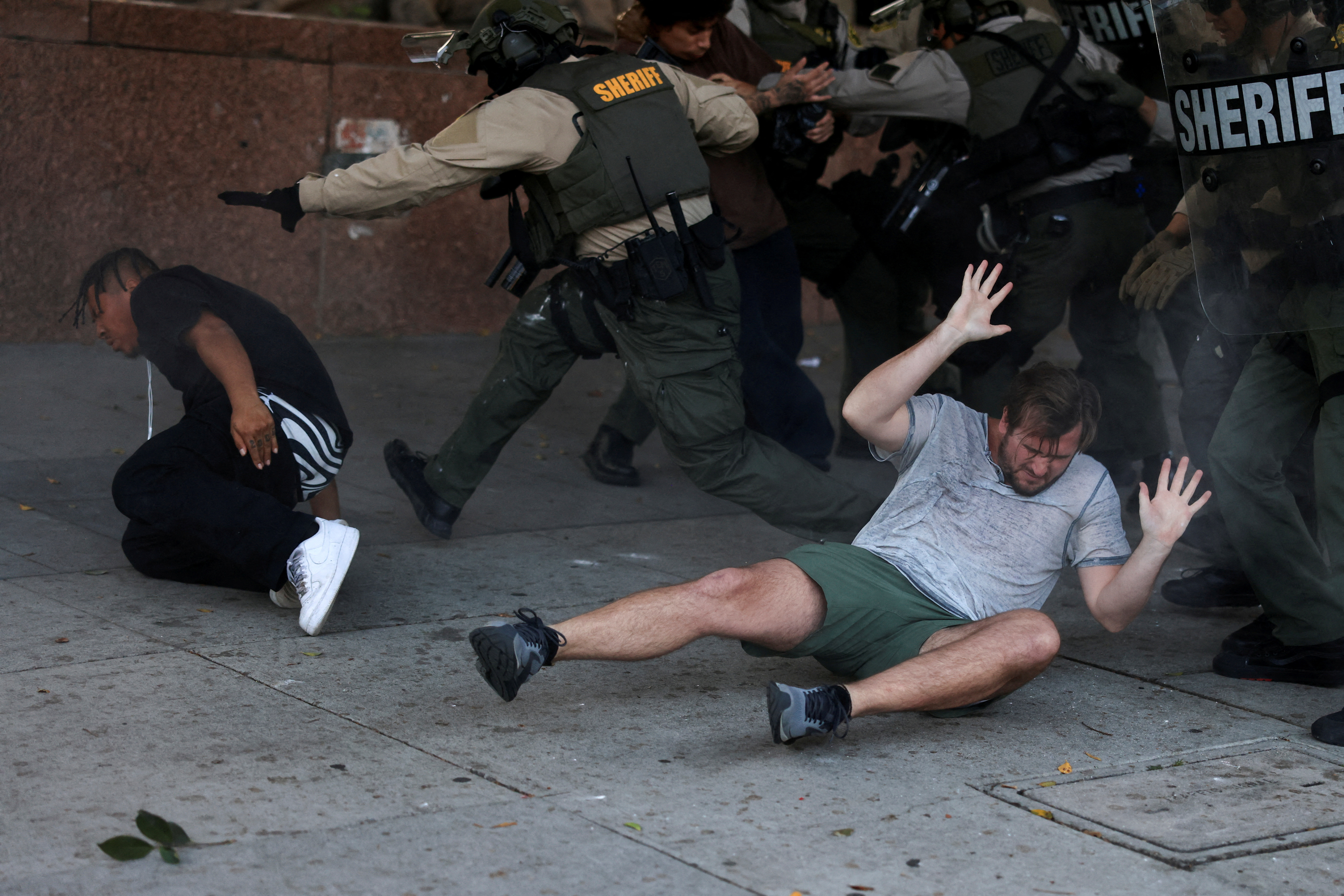 Protesters react on the ground during a clash with law enforcement officers at a protest against federal immigration sweeps, in Los Angeles, California, U.S., June 11, 2025. REUTERS/David Swanson TPX IMAGES OF THE DAY