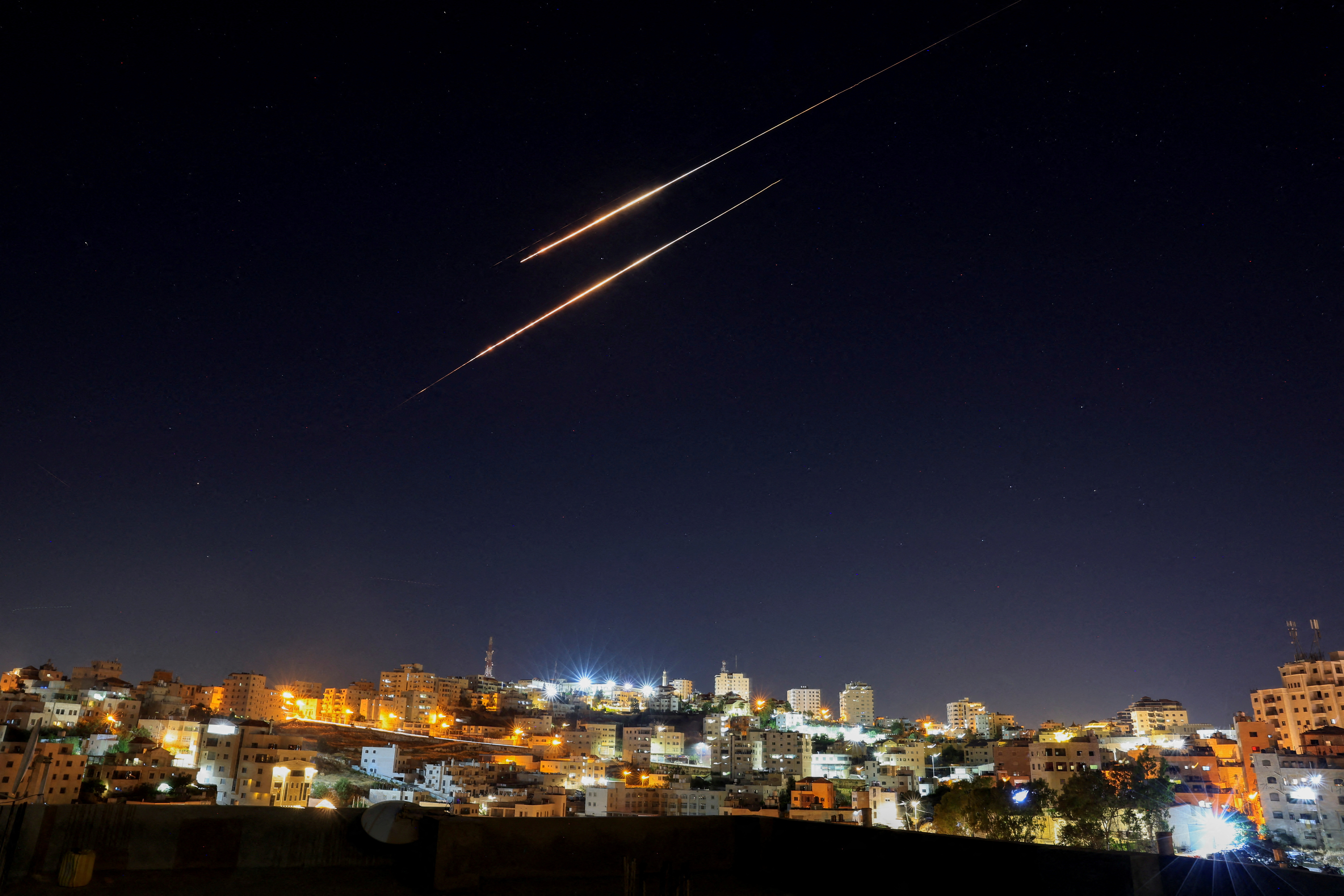 Missiles launched from Iran towards Israel are seen from Hebron, in the Israeli-occupied West Bank, June 19, 2025. [Mussa Issa Qawasma/Reuters]