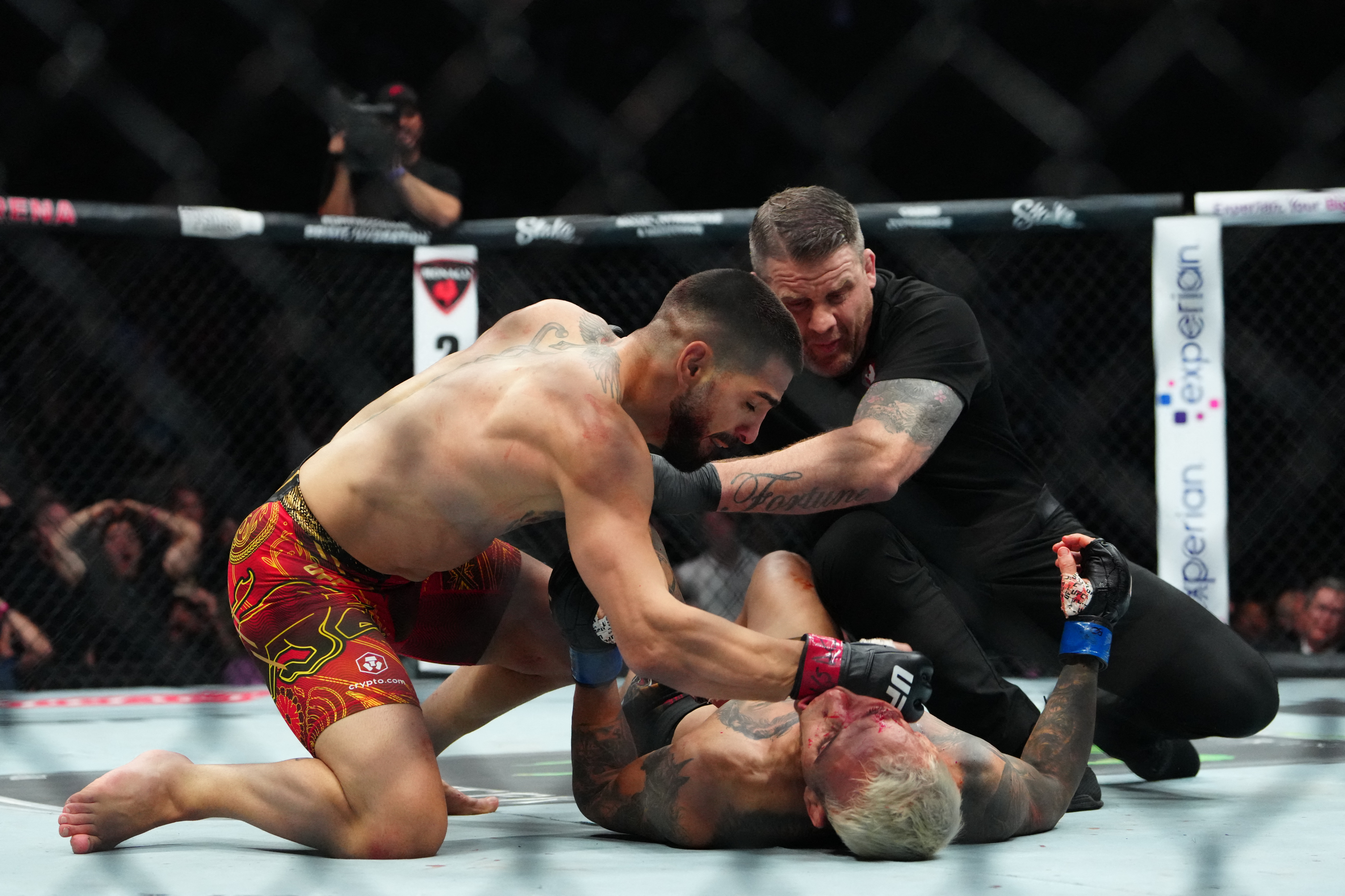 Oliveira lies unconscious as refreer Maric Goddard pulls Topuria off him