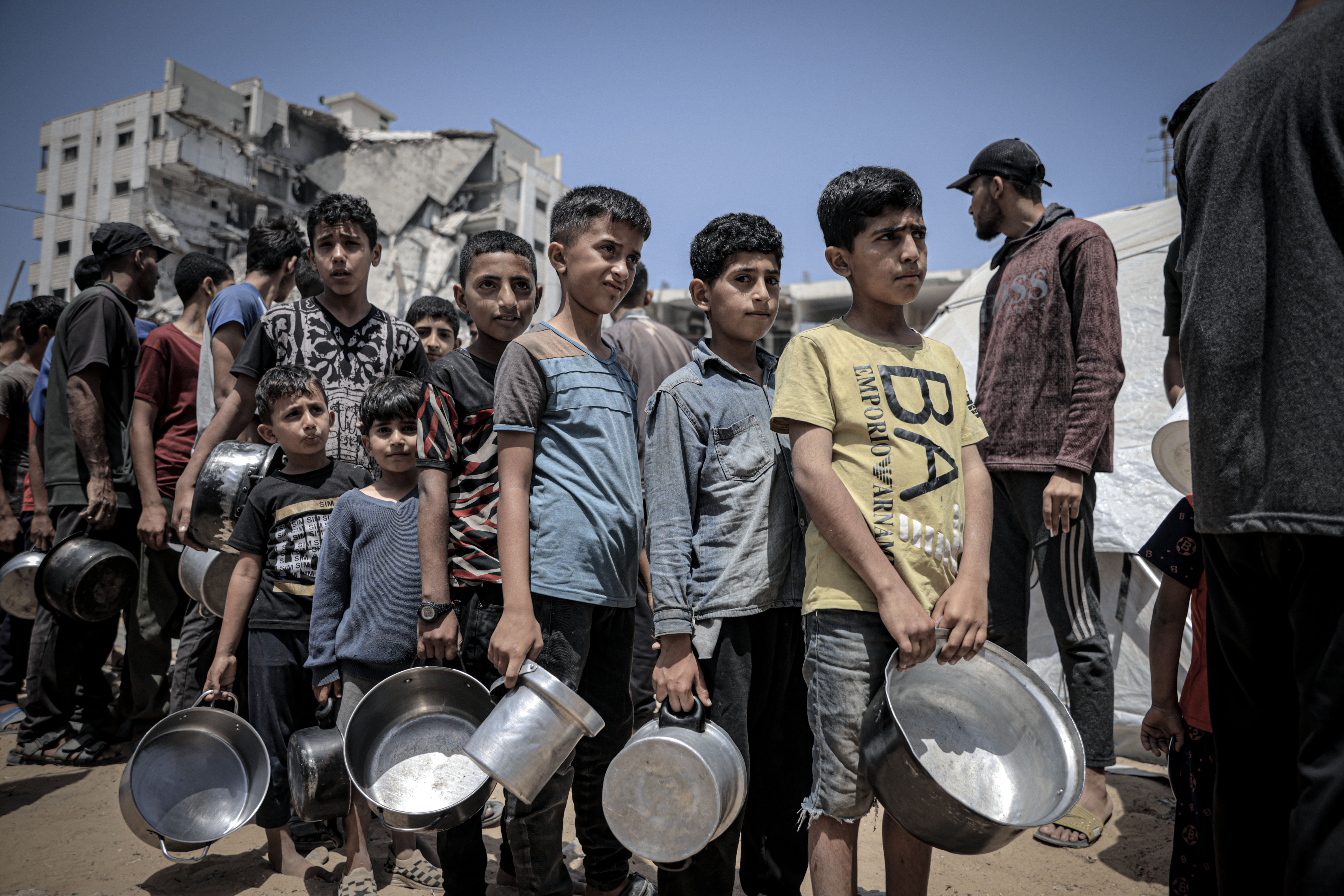 GAZA CITY, GAZA - MAY 31: Palestinians including women and children living in tents receive food distributed by aid organizations in al Mawasi district of Khan Yunis, Gaza on May 30, 2025. The situation highlights the growing desperation and urgent need for humanitarian assistance in the region. ( Ahmed Jihad Ibrahim Al-arini - Anadolu Agency )